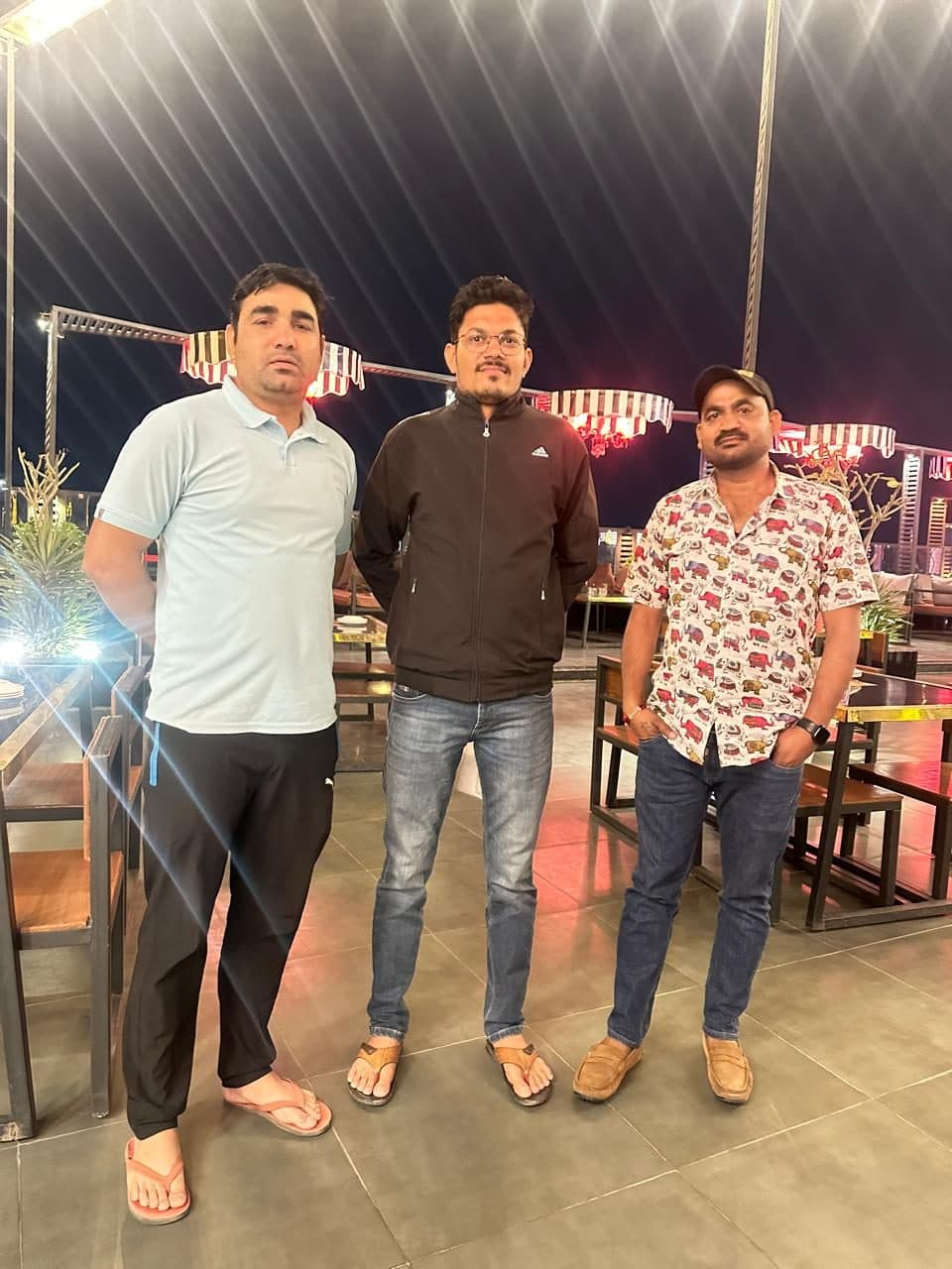 Three men on a rooftop cafe in the evening, the guide among them