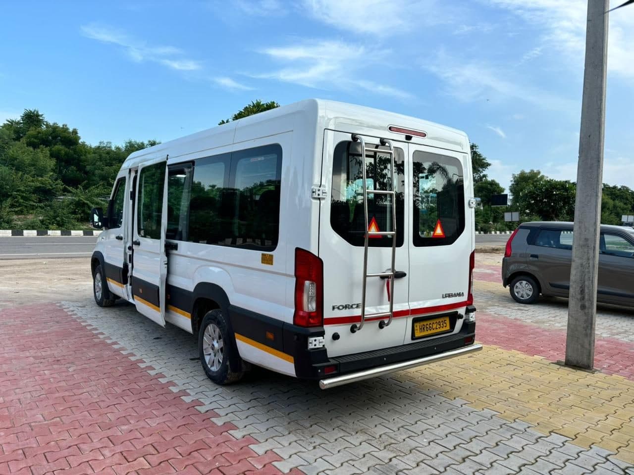 The rear of a white Force Urbania coach in a covered car park, doors open for loading