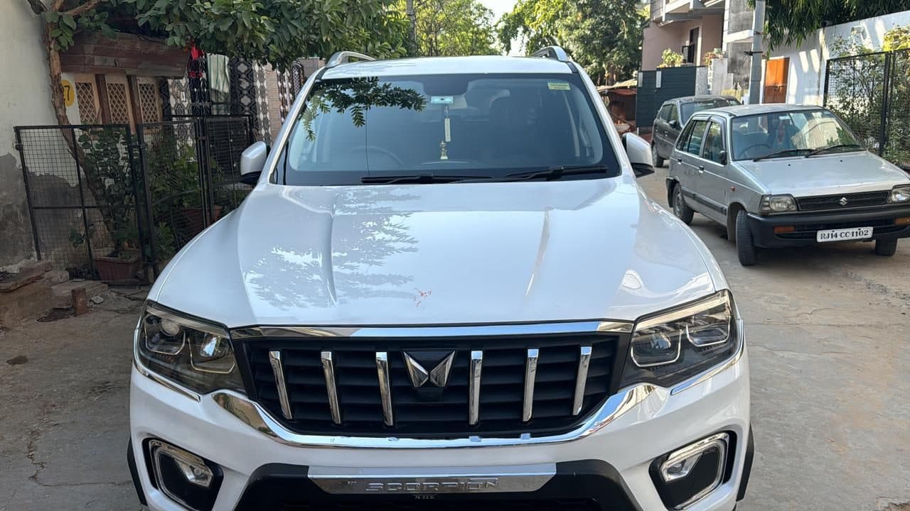 A white Mahindra SUV pulled up kerbside at a hotel gate