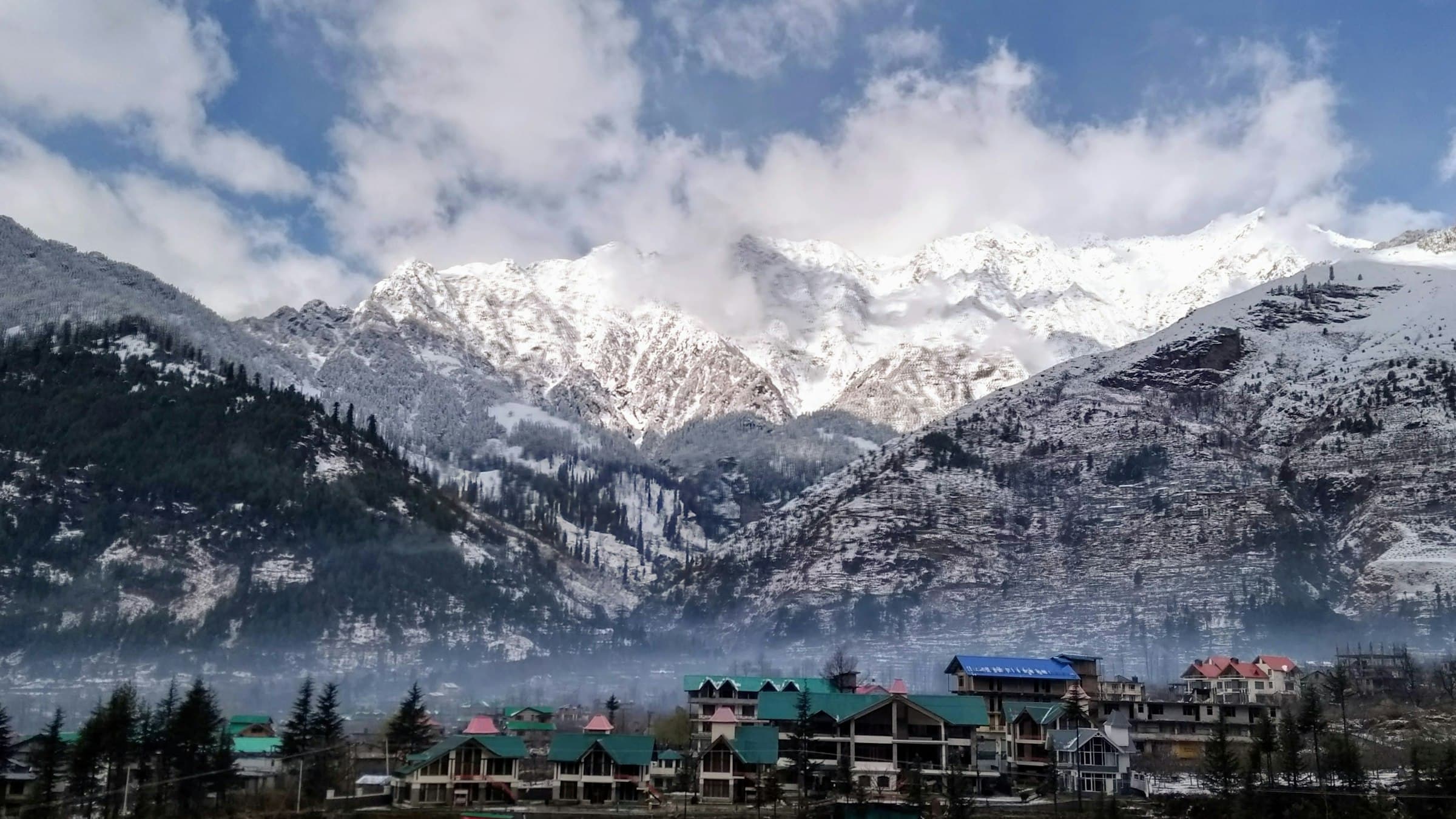 Snow-covered mountains above a small town in the Manali valley, Himachal Pradesh