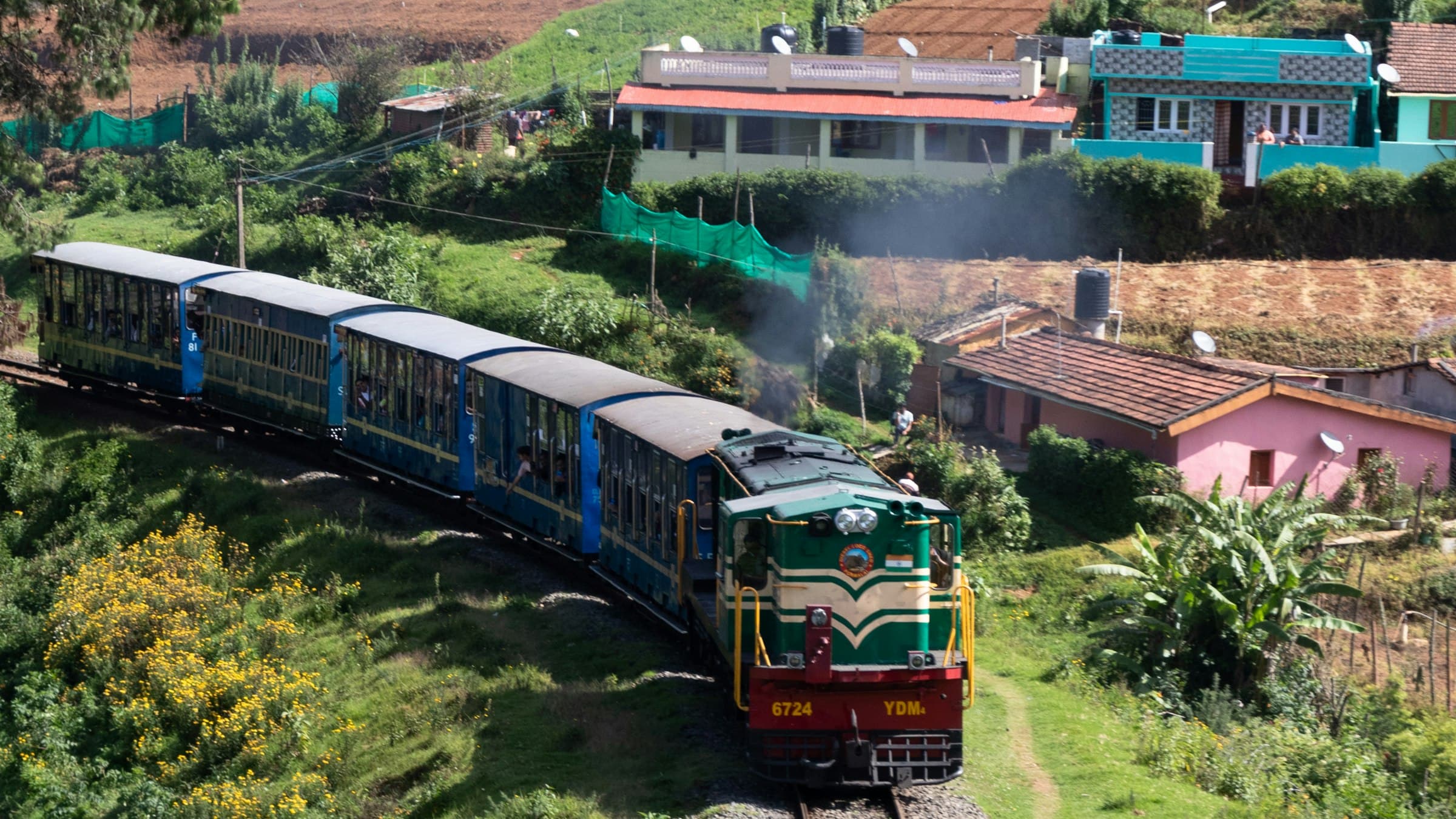 Nilgiri Mountain Railway train traveling through green hills near Ooty, Tamil Nadu