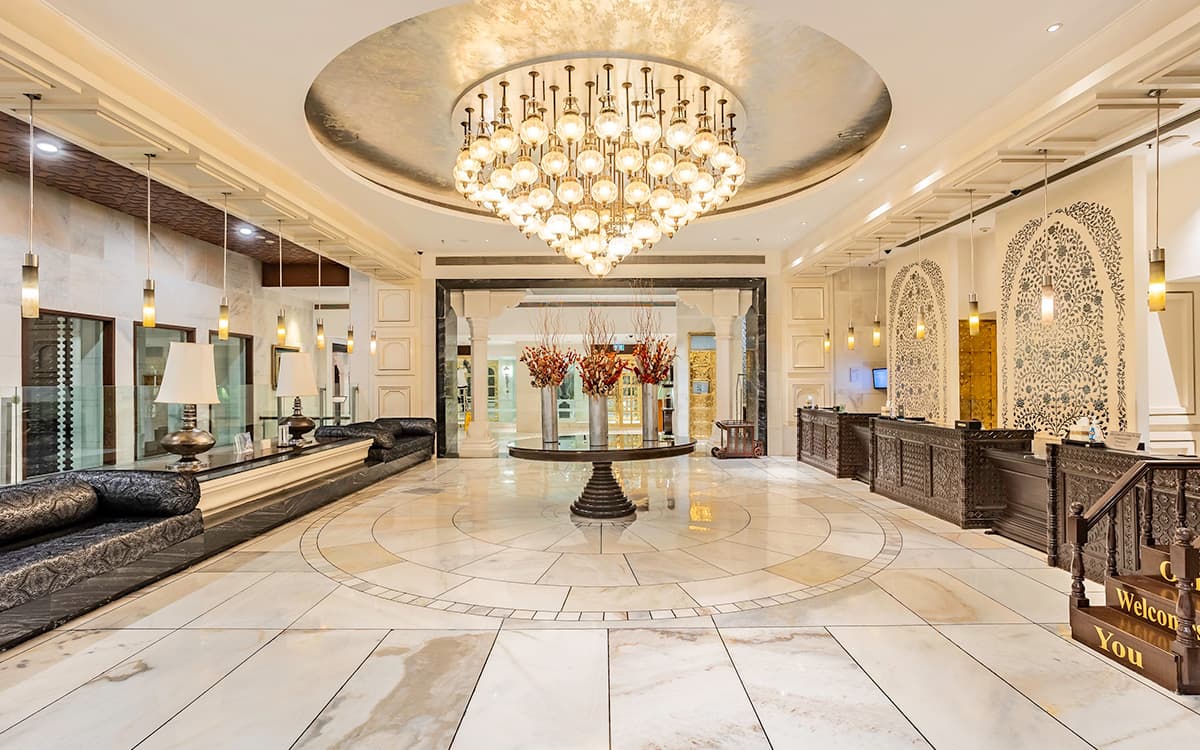 The Akbar Mahal lobby at ITC Mughal, with marble floors and a large chandelier