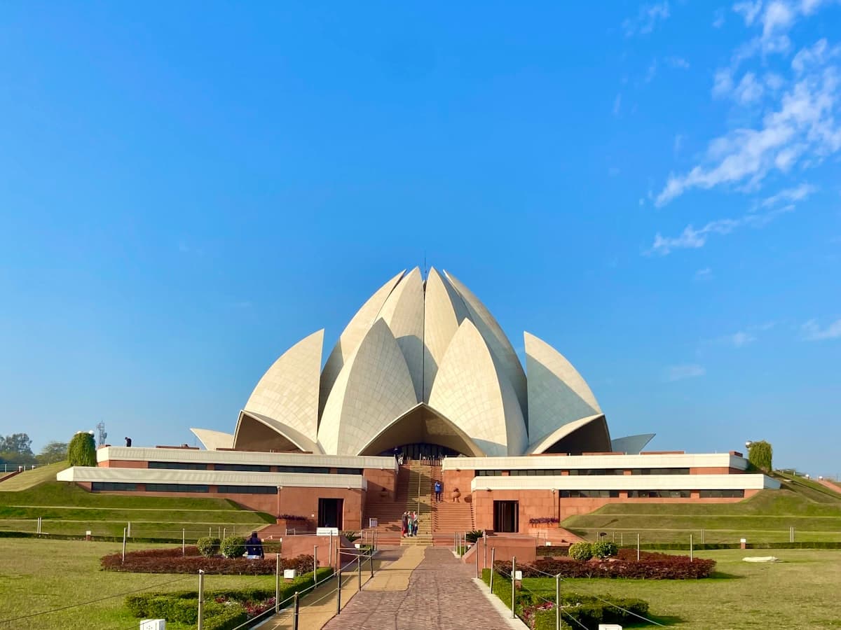 The white marble petals of the lotus-shaped Bahá'í House of Worship in New Delhi, approached by its long processional walkway.
