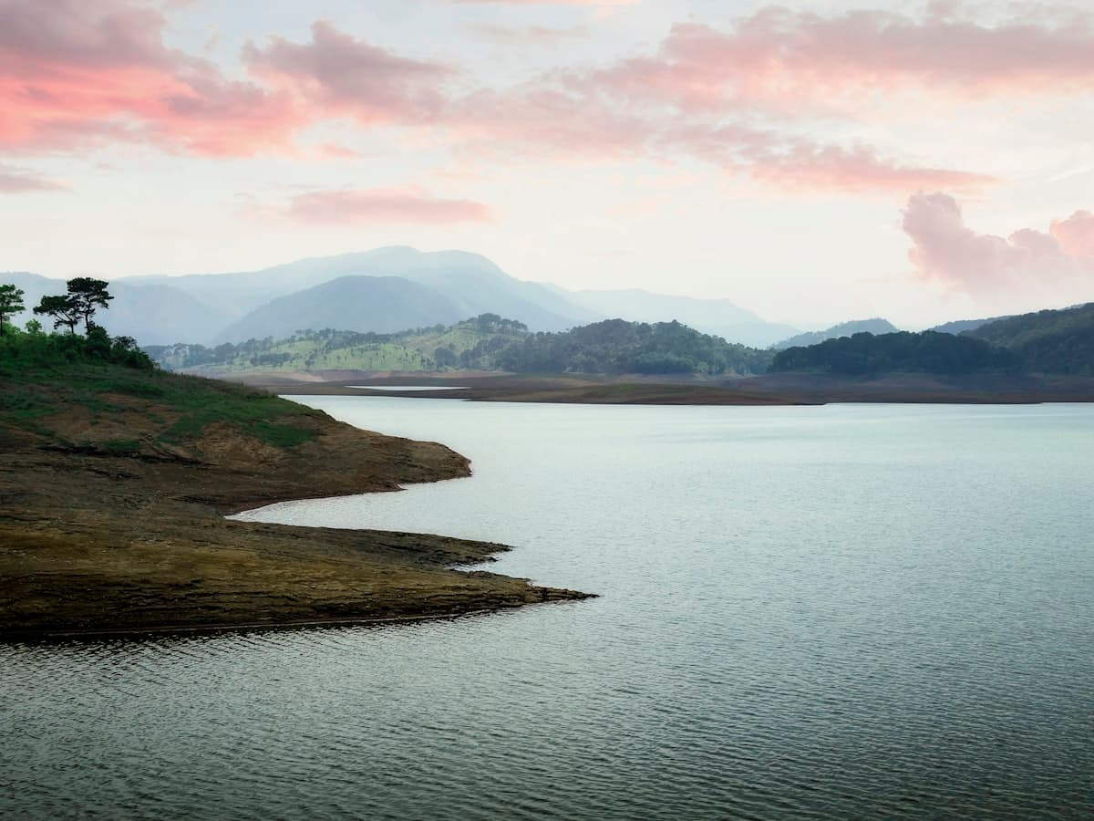 The wide reservoir of Umiam Lake at sunset, ringed by forested hills near Shillong, Meghalaya.