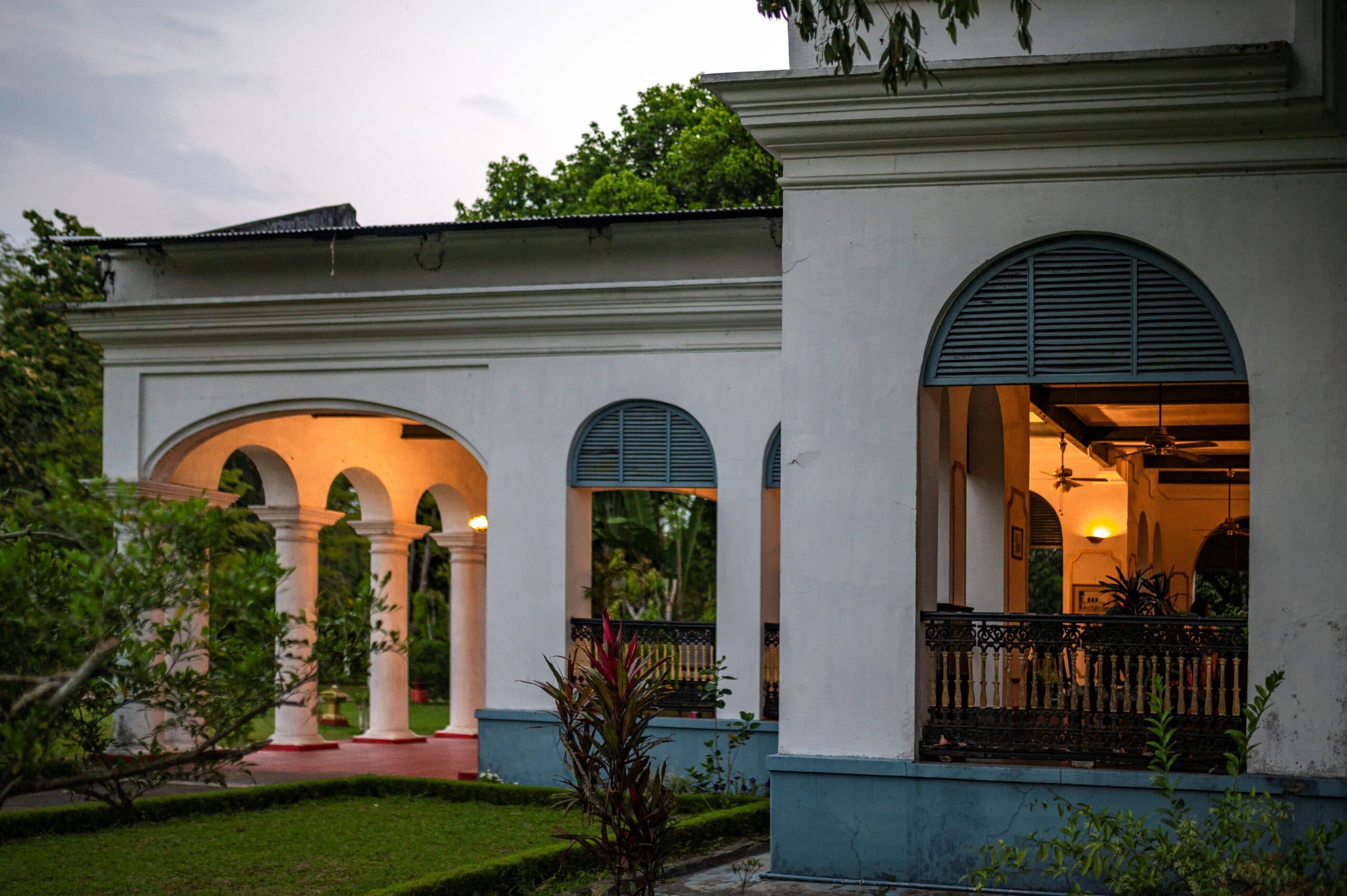 The arched colonnaded verandah of Thengal Manor at dusk.