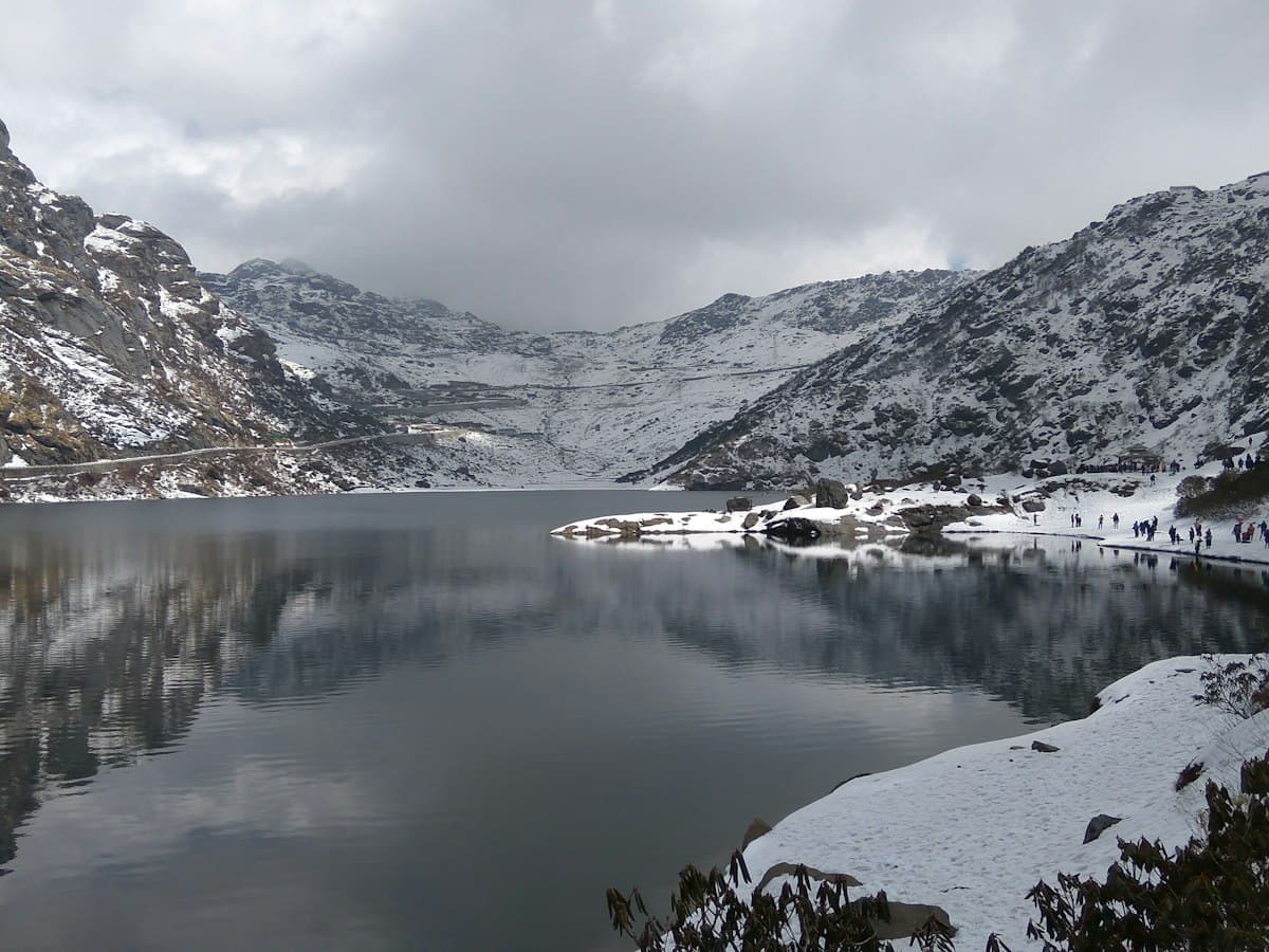The glacial Tsomgo (Changu) Lake in East Sikkim ringed by bare snow-streaked mountains.