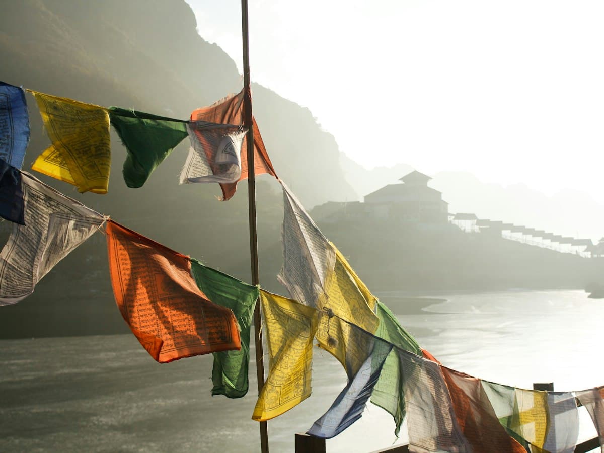 Colourful Buddhist prayer flags strung from a wooden pole on the high-altitude road between Gangtok and the Nathu La border, Sikkim.