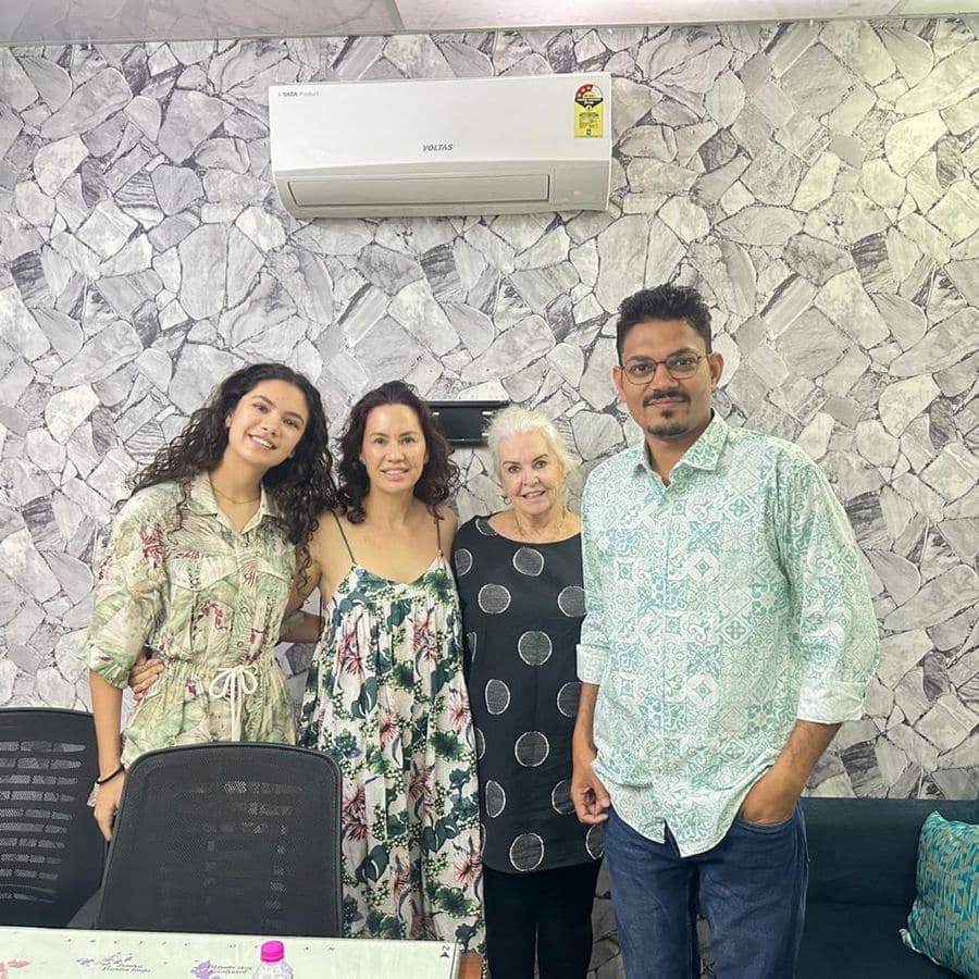 Three guests posing with a team member inside the Lux India Tours office
