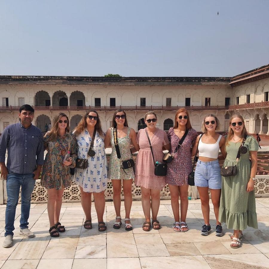A group of eight guests and their guide standing in the courtyard of Amber Fort