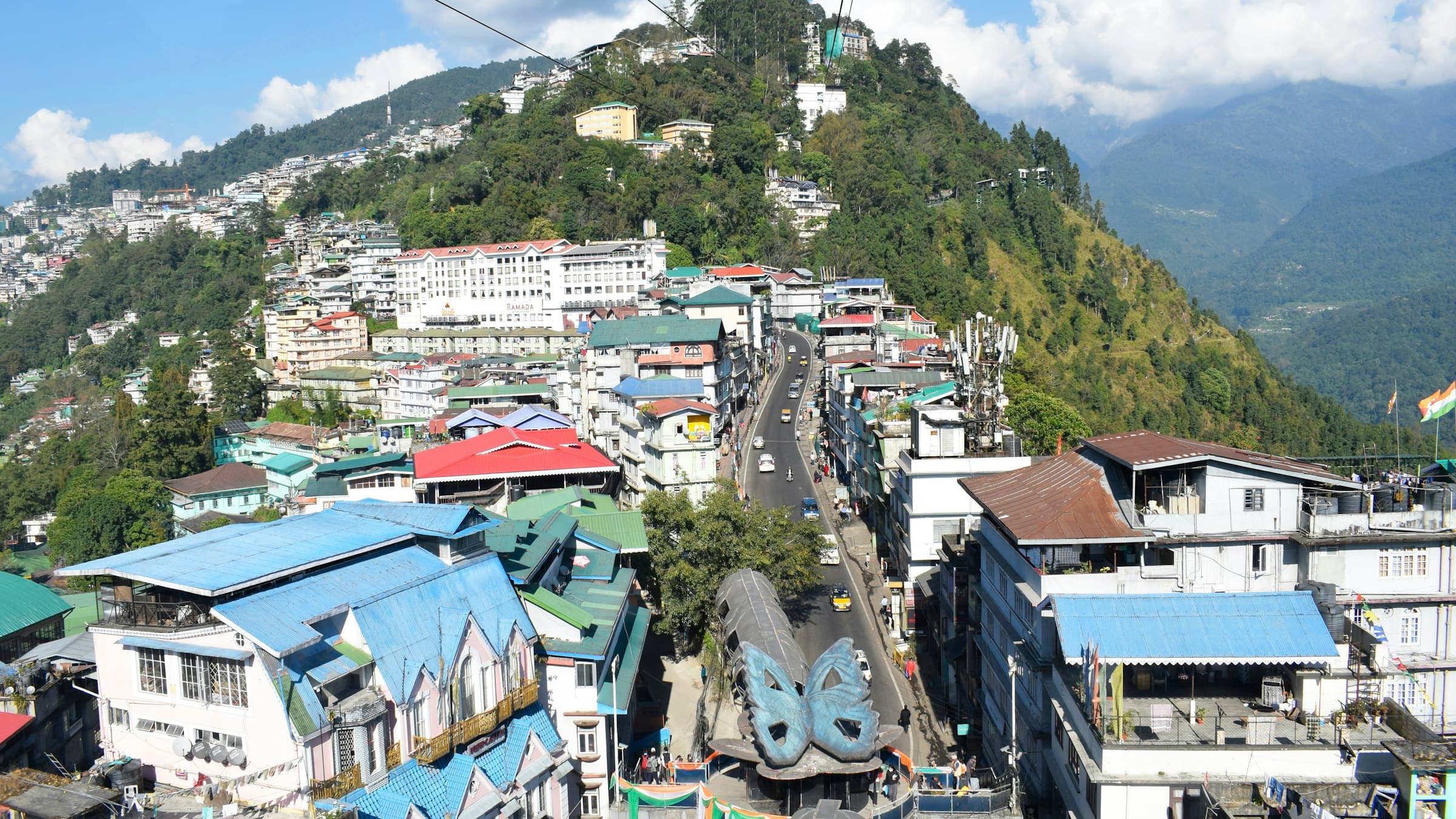 Hillside town of Gangtok, Sikkim, layered with buildings under a blue sky