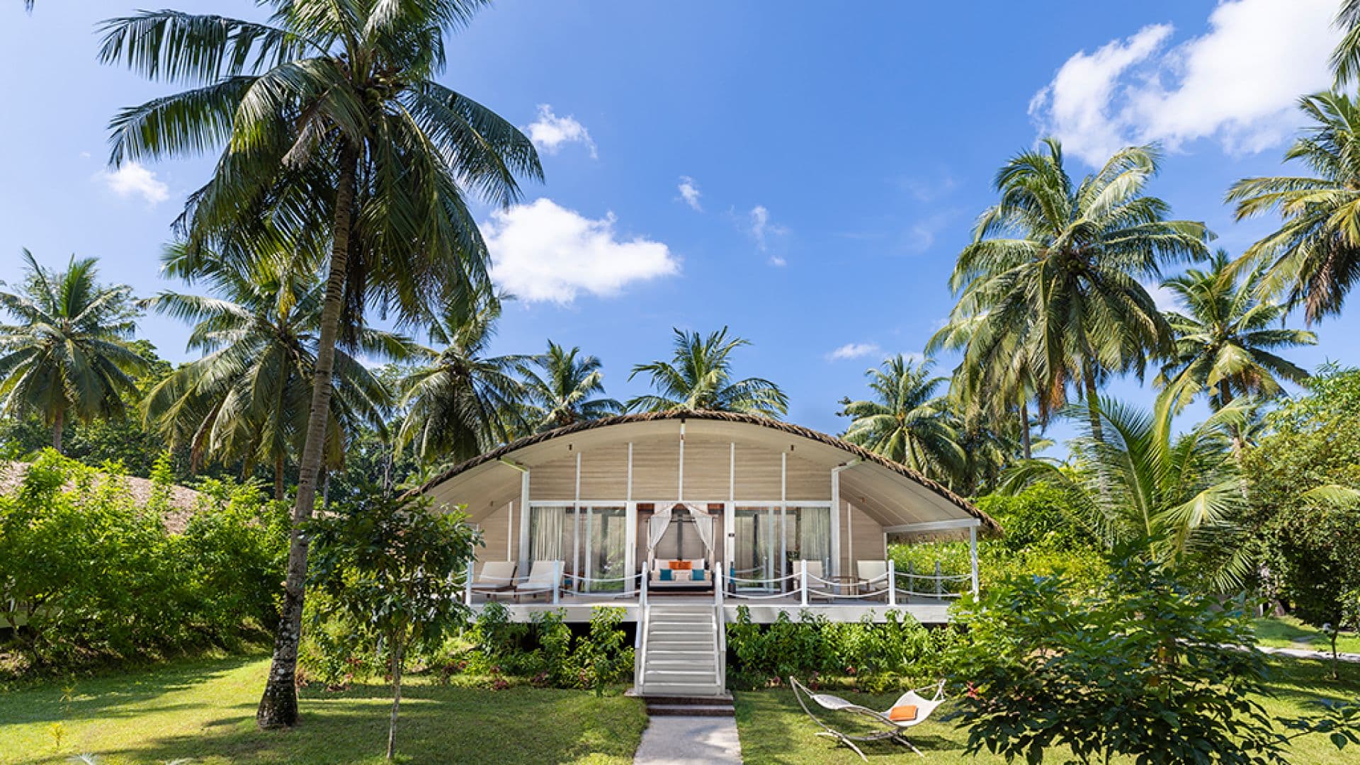 Deluxe Villa at Taj Exotica Andamans with stilted thatched-roof architecture among the trees