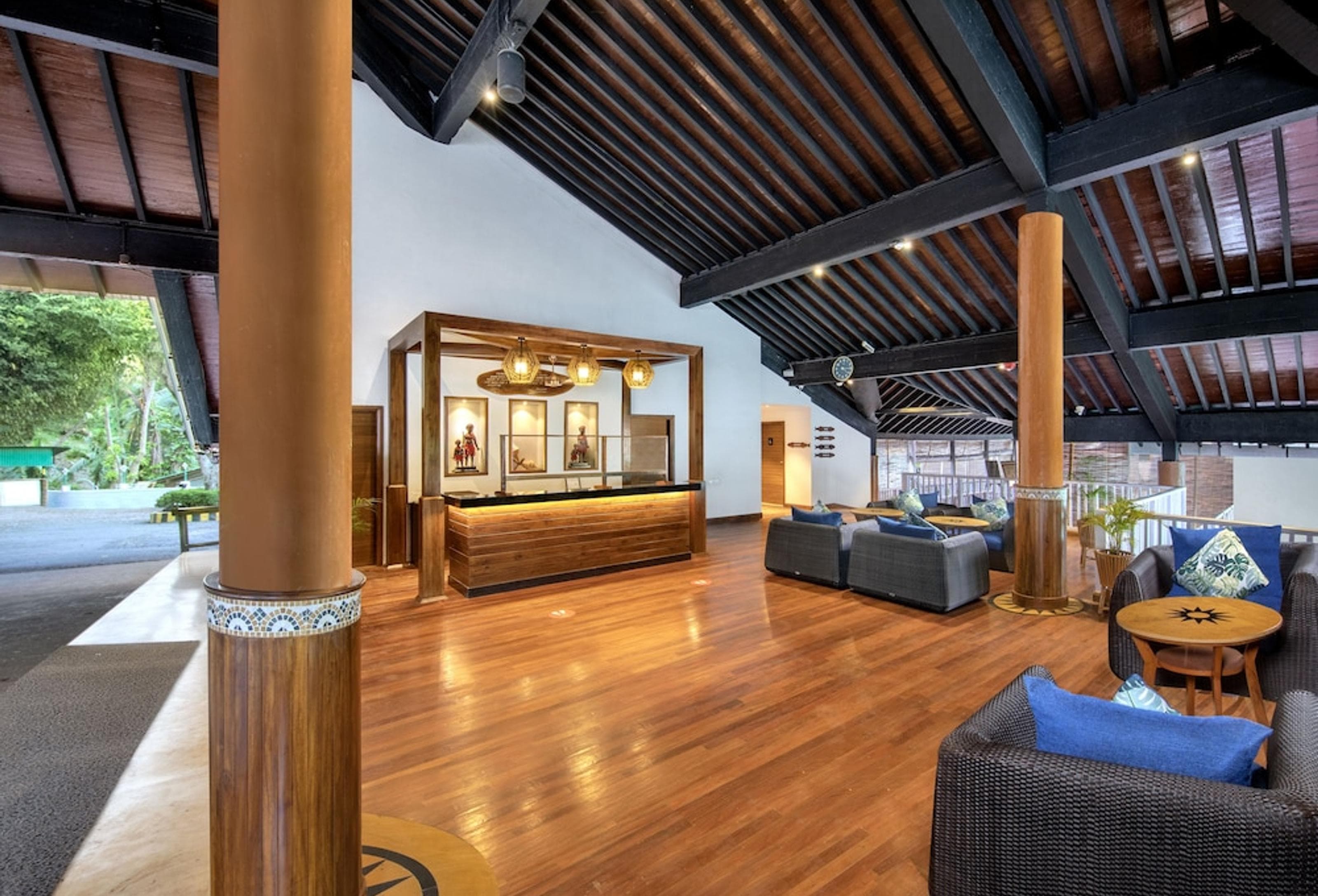 Reception lobby at Welcomhotel Bay Island with exposed timber roof beams and polished wood floors