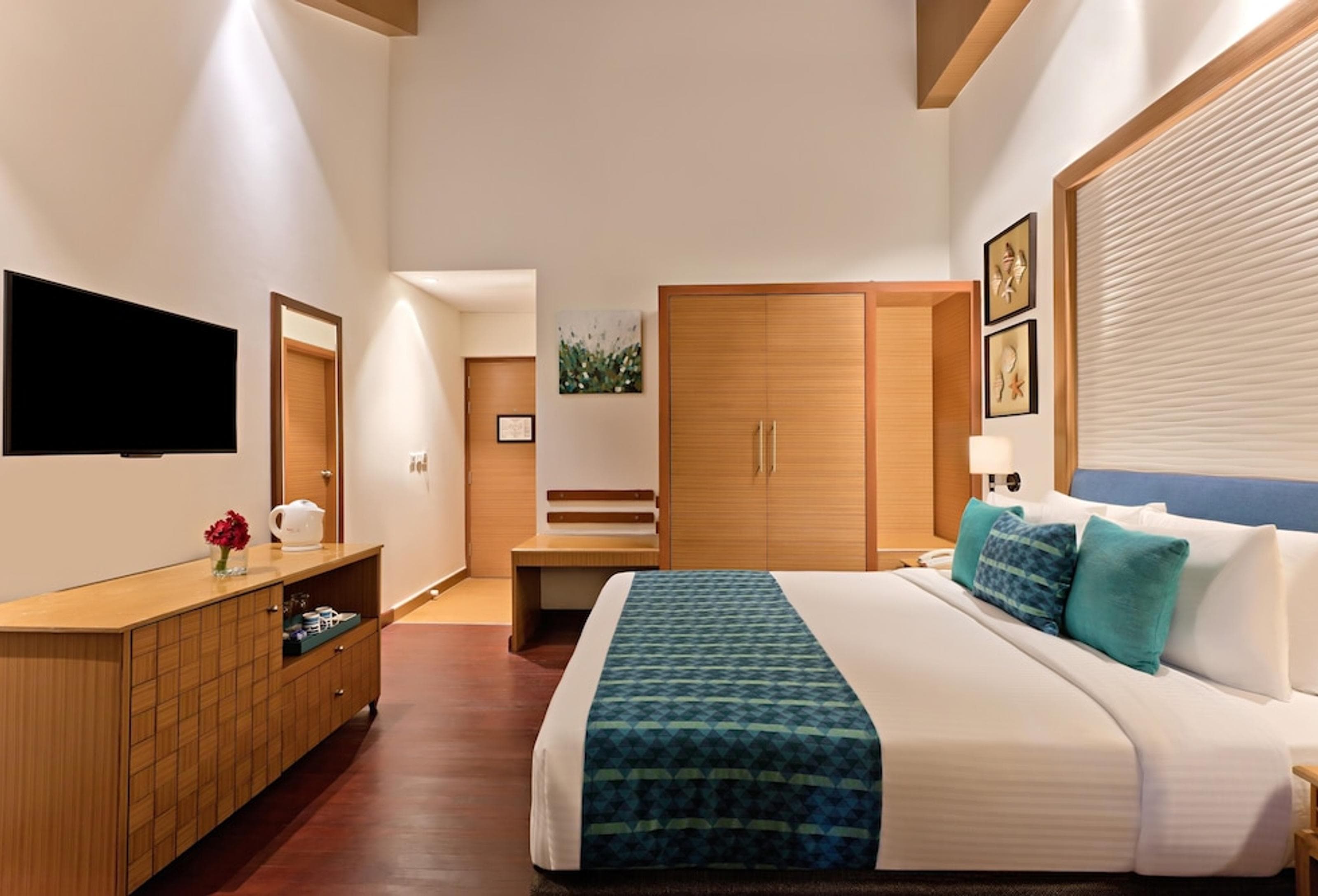 Deluxe Room at Welcomhotel Bay Island with king bed and sloped timber-beamed ceiling