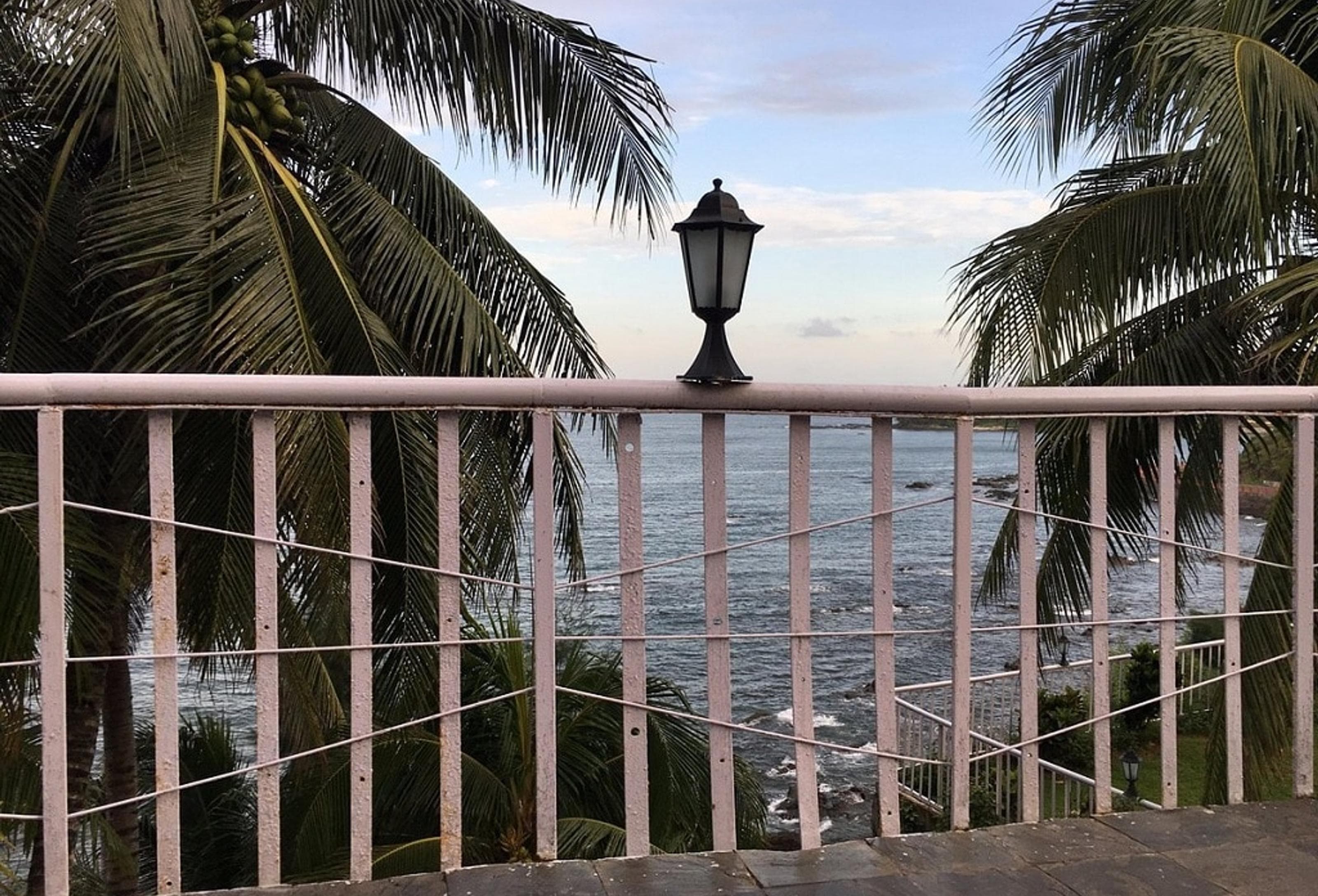 View of the Bay of Bengal from a balcony at Sinclairs Bayview Port Blair, framed by coconut palms