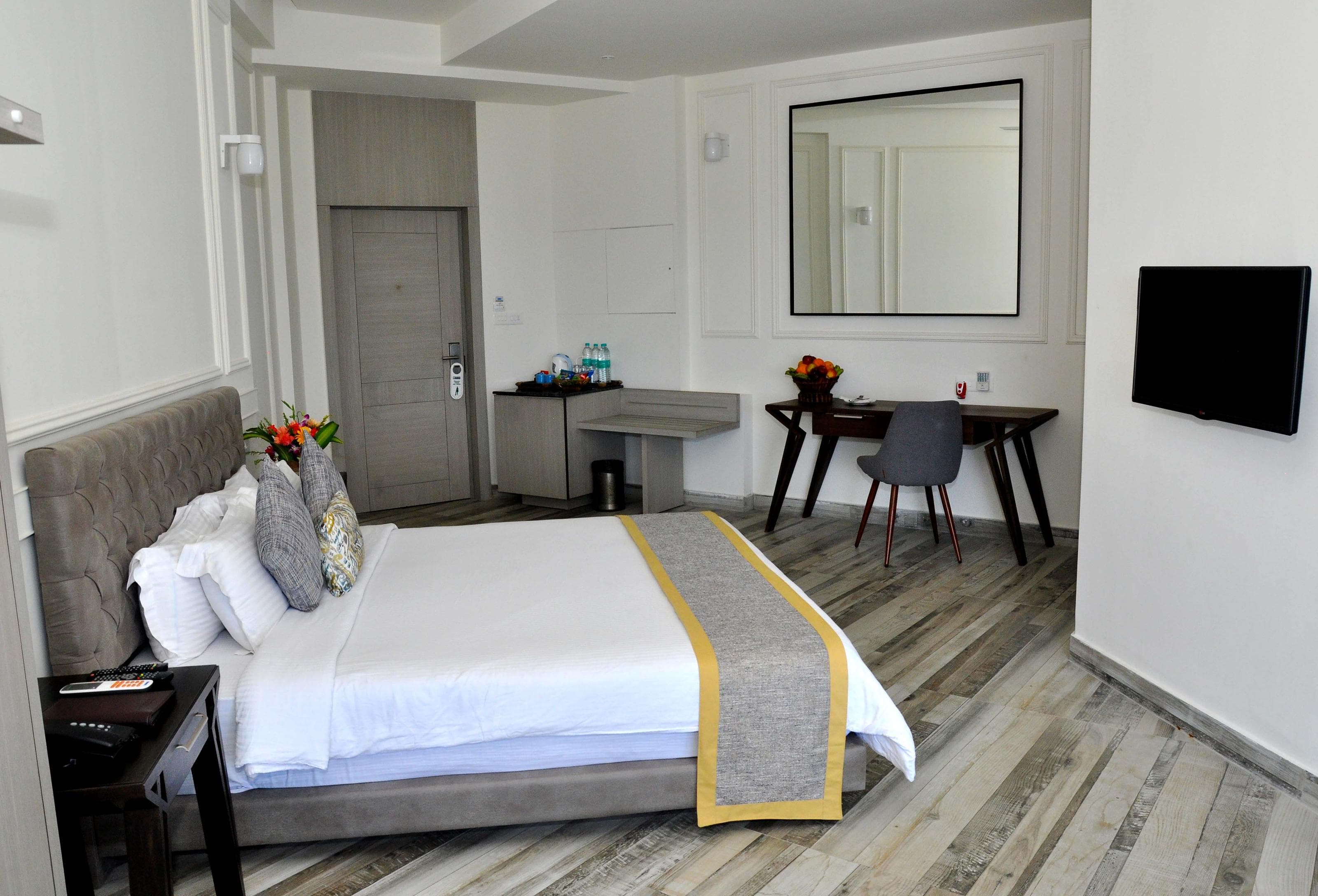 Premier Suite bedroom at Sinclairs Bayview Port Blair with tufted headboard and writing desk