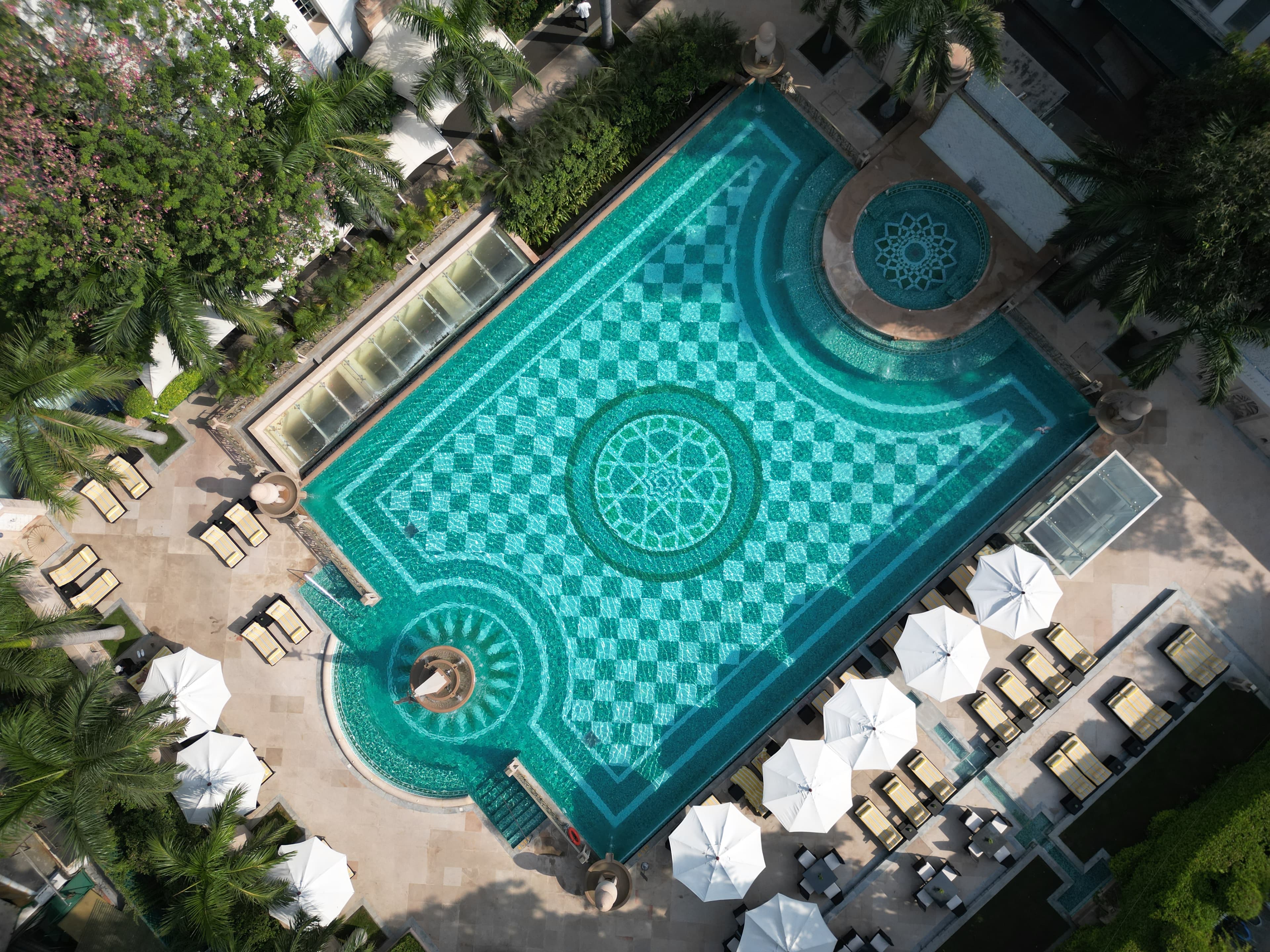 The Imperial's outdoor pool bordered by colonnades and manicured lawns
