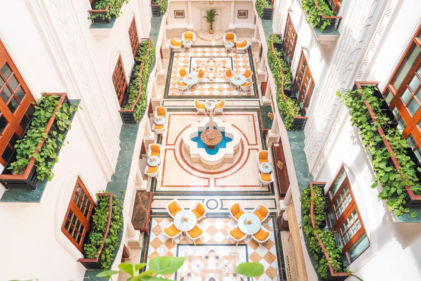 Aerial view down The Imperial New Delhi's colonial-era Atrium courtyard, with marble-inlaid flooring and a central fountain