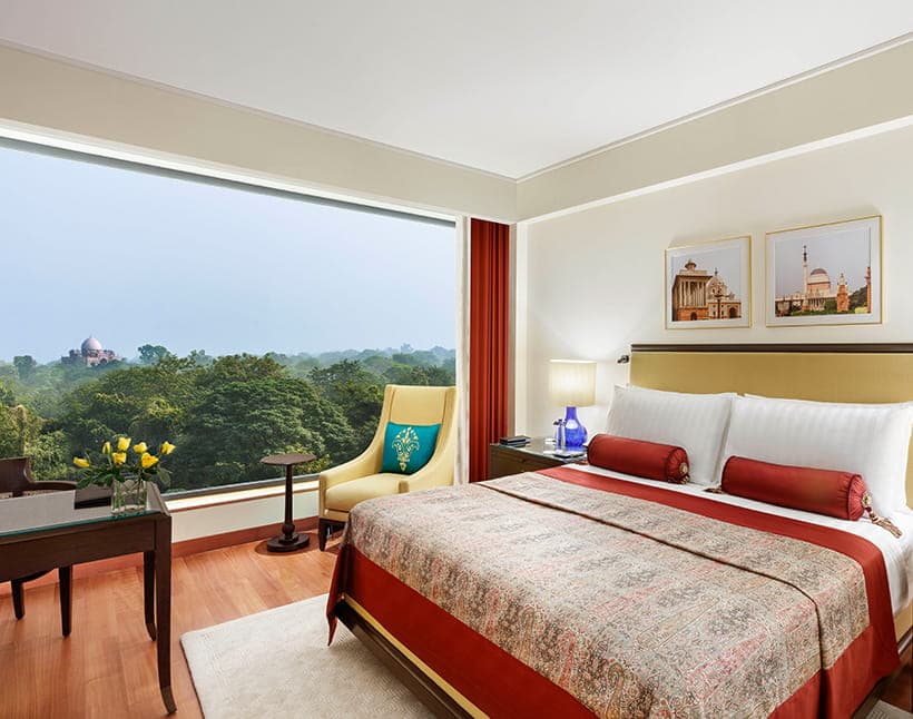 A Luxury Room at The Oberoi, New Delhi with a large picture window overlooking the grounds