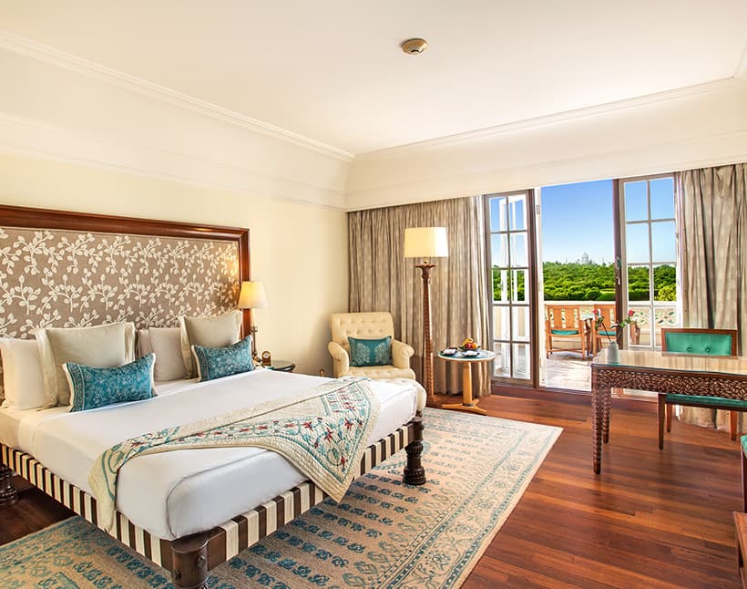 A Premier Room with Balcony at The Oberoi Amarvilas, with the Taj Mahal visible through the open balcony doors