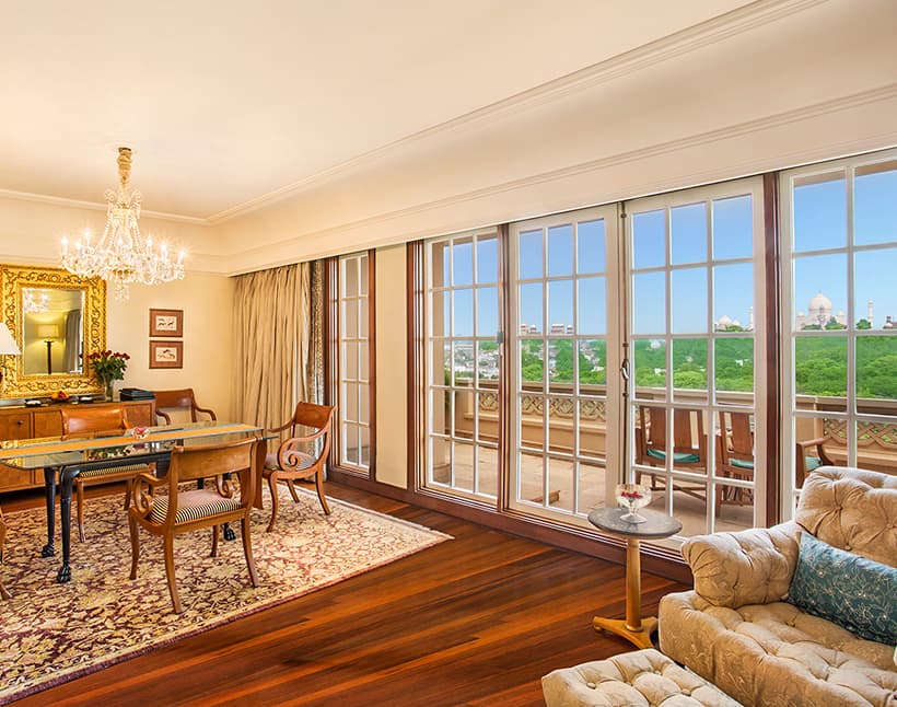 The living area of a Luxury Suite at The Oberoi Amarvilas, with the Taj Mahal visible through floor-to-ceiling windows
