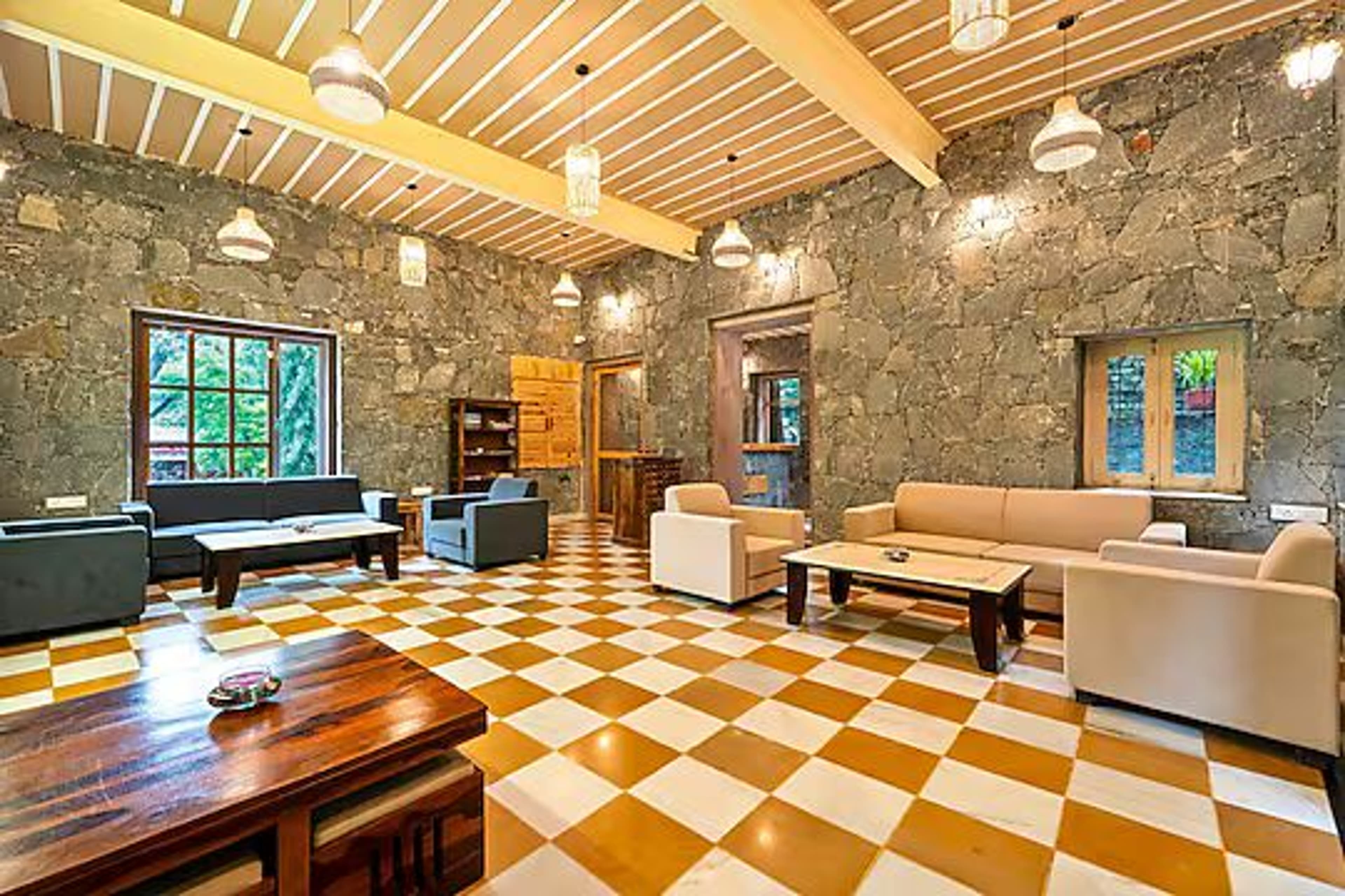 The Aodhi's stone-walled lounge with high wood-beamed ceiling and garden-facing windows