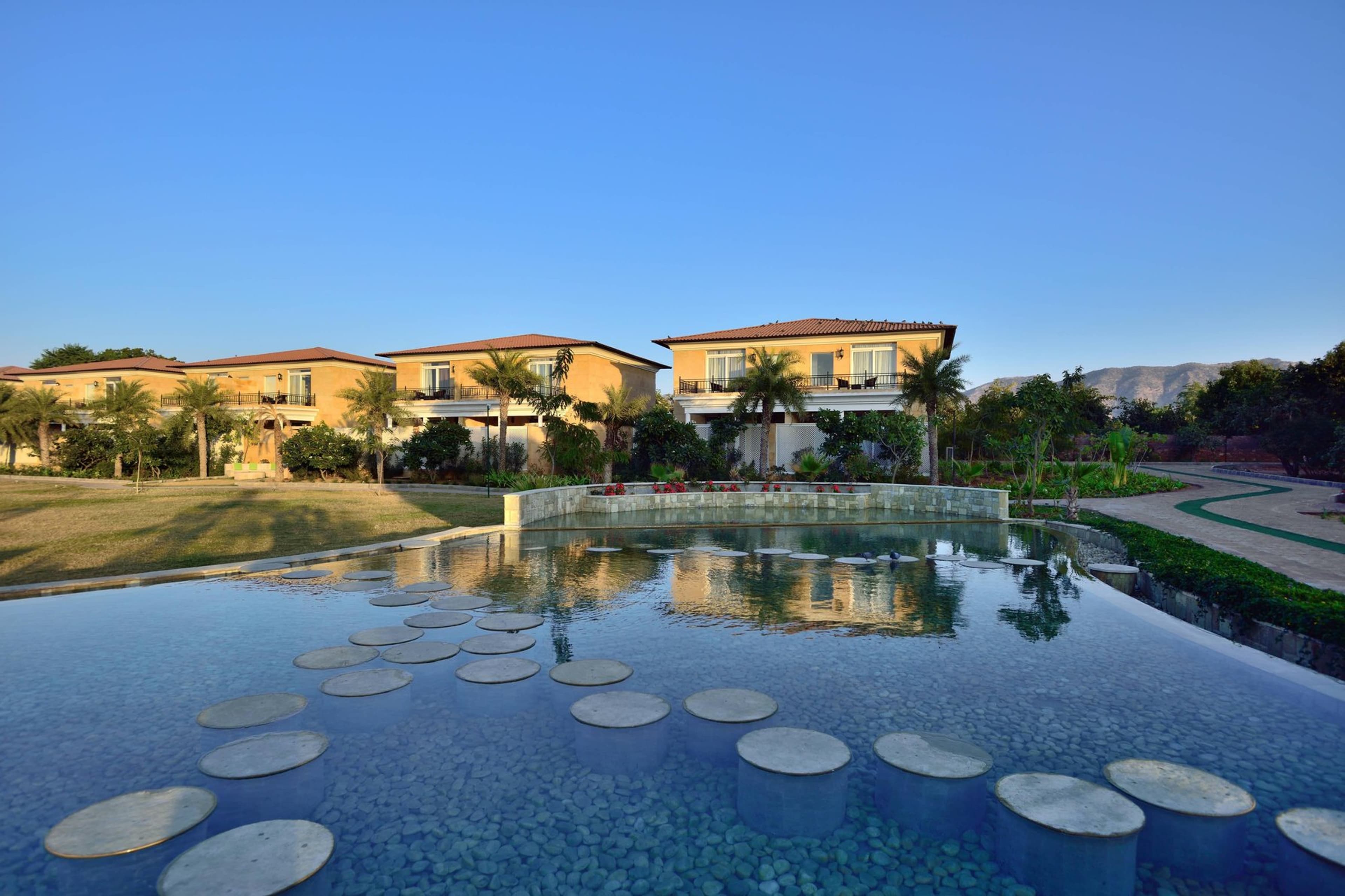 The Westin Pushkar Resort & Spa's reflecting water feature with guest villas and the Aravalli hills behind