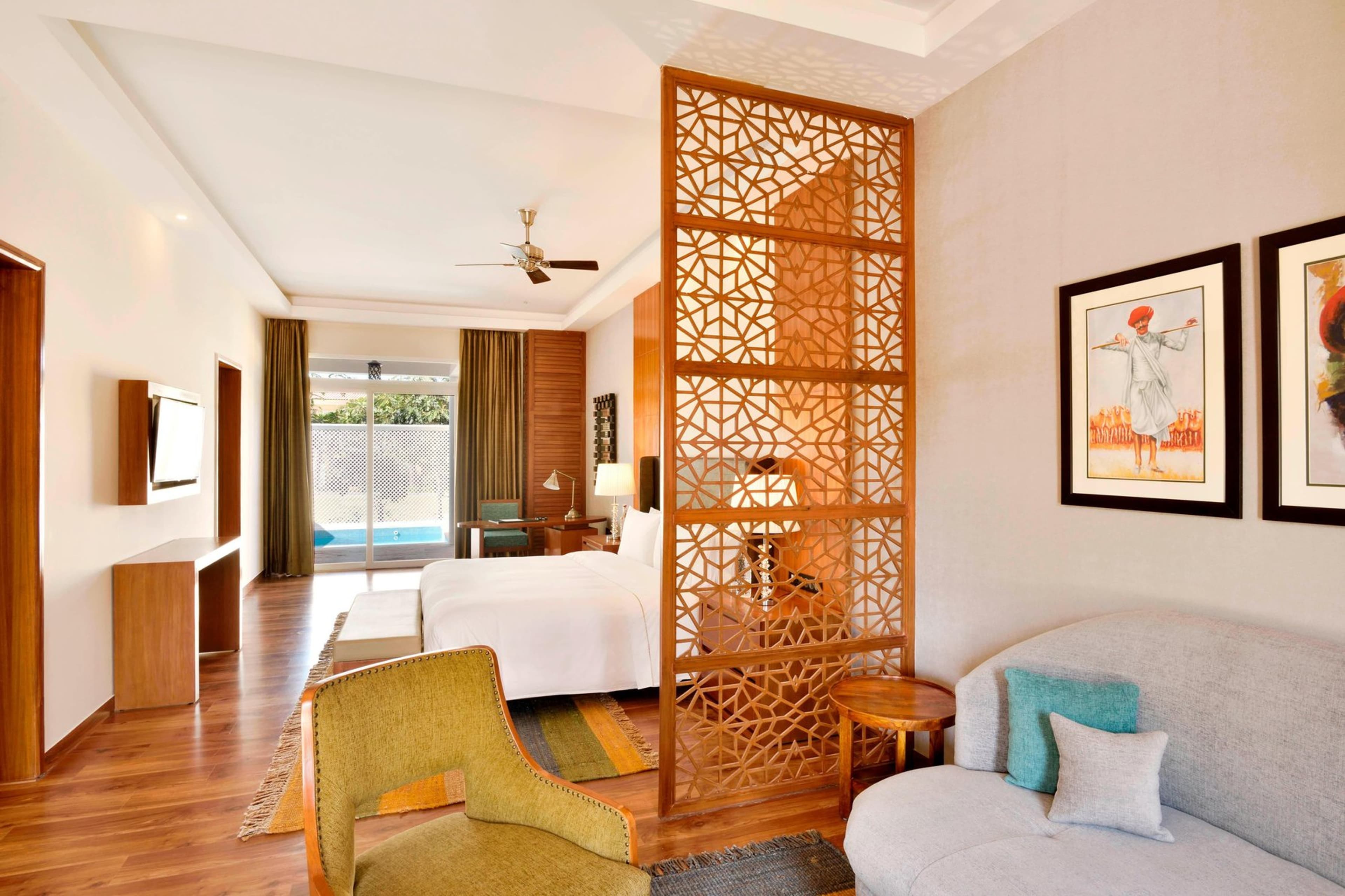 A Westin Pushkar Luxury Suite bedroom opening through sliding doors onto its private plunge pool and patio