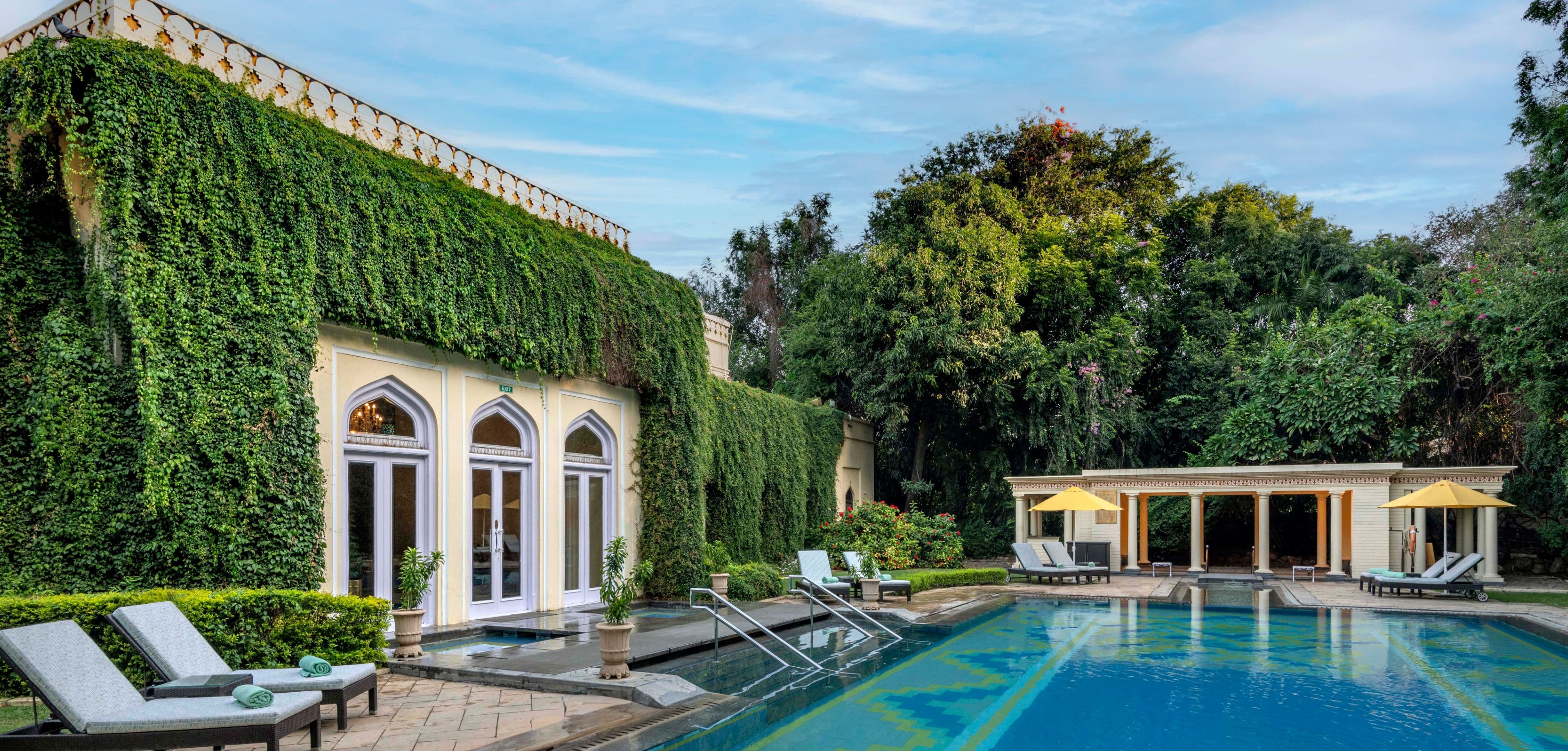 The outdoor pool at Rambagh Palace, Jaipur, framed by colonnaded walkways and clipped lawns