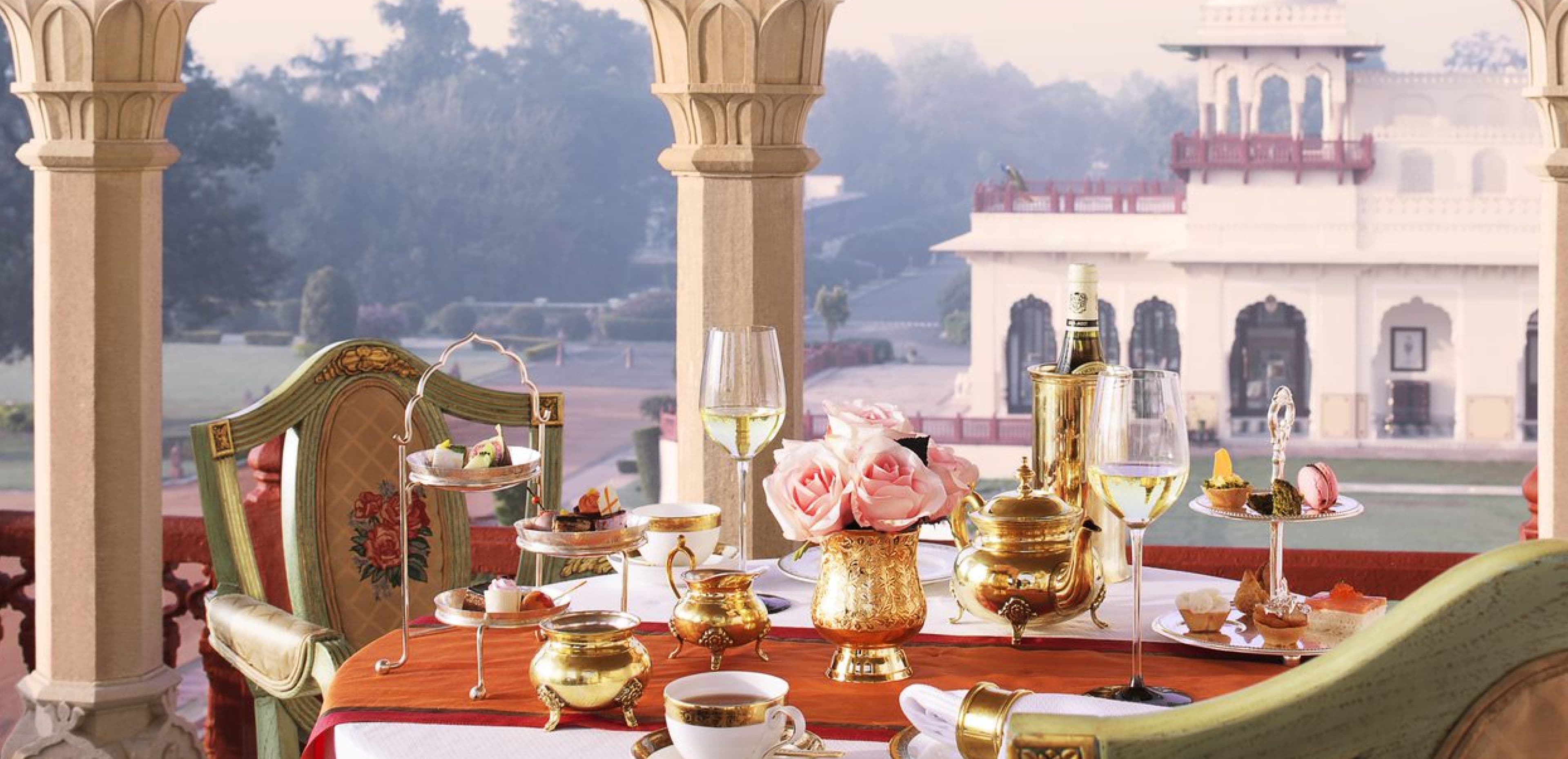 A royal dining setting at Rambagh Palace, Jaipur, laid with silver under chandeliers