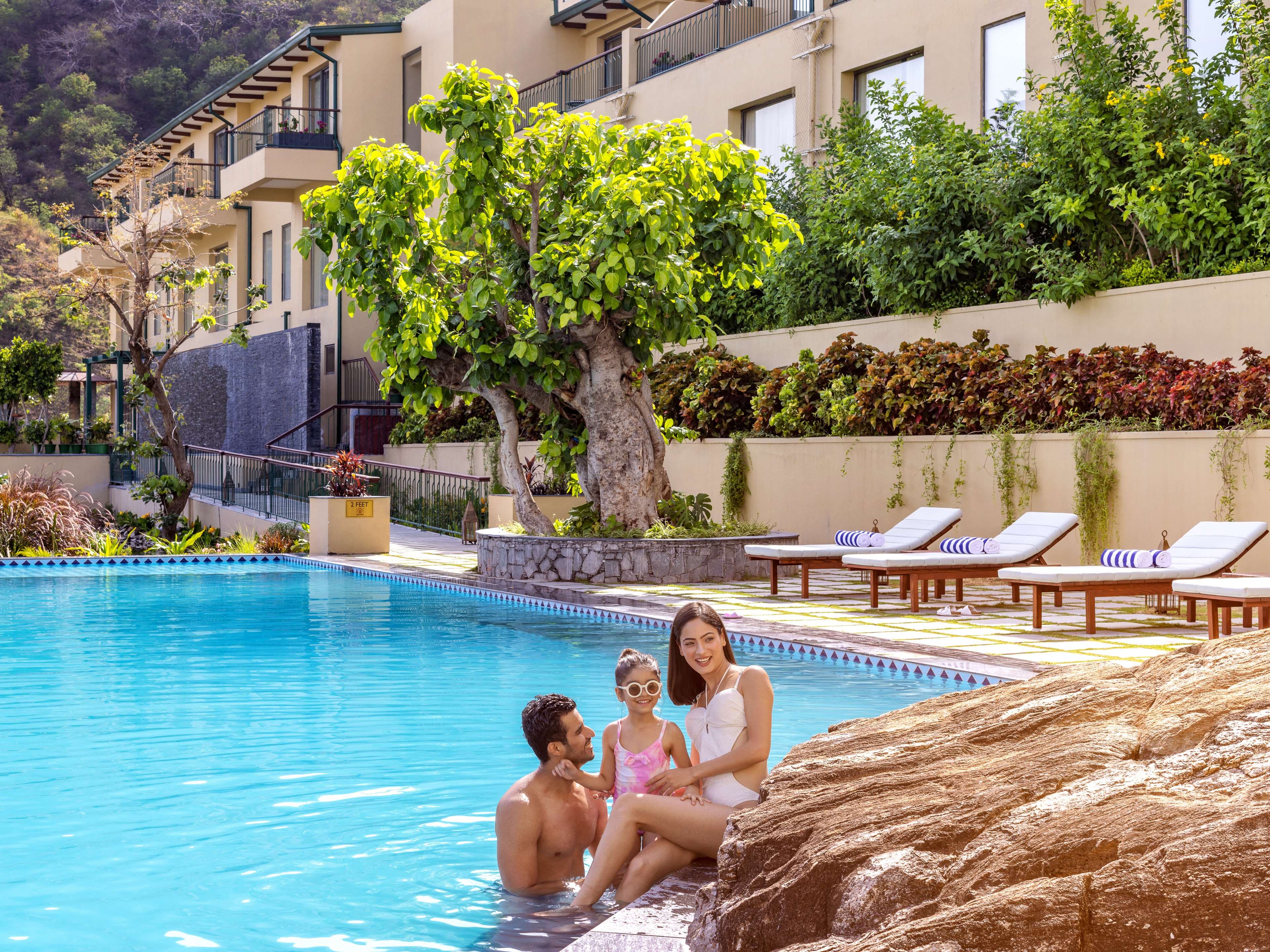 The outdoor pool at Radisson Blu Resort Kumbhalgarh with loungers and the hills beyond