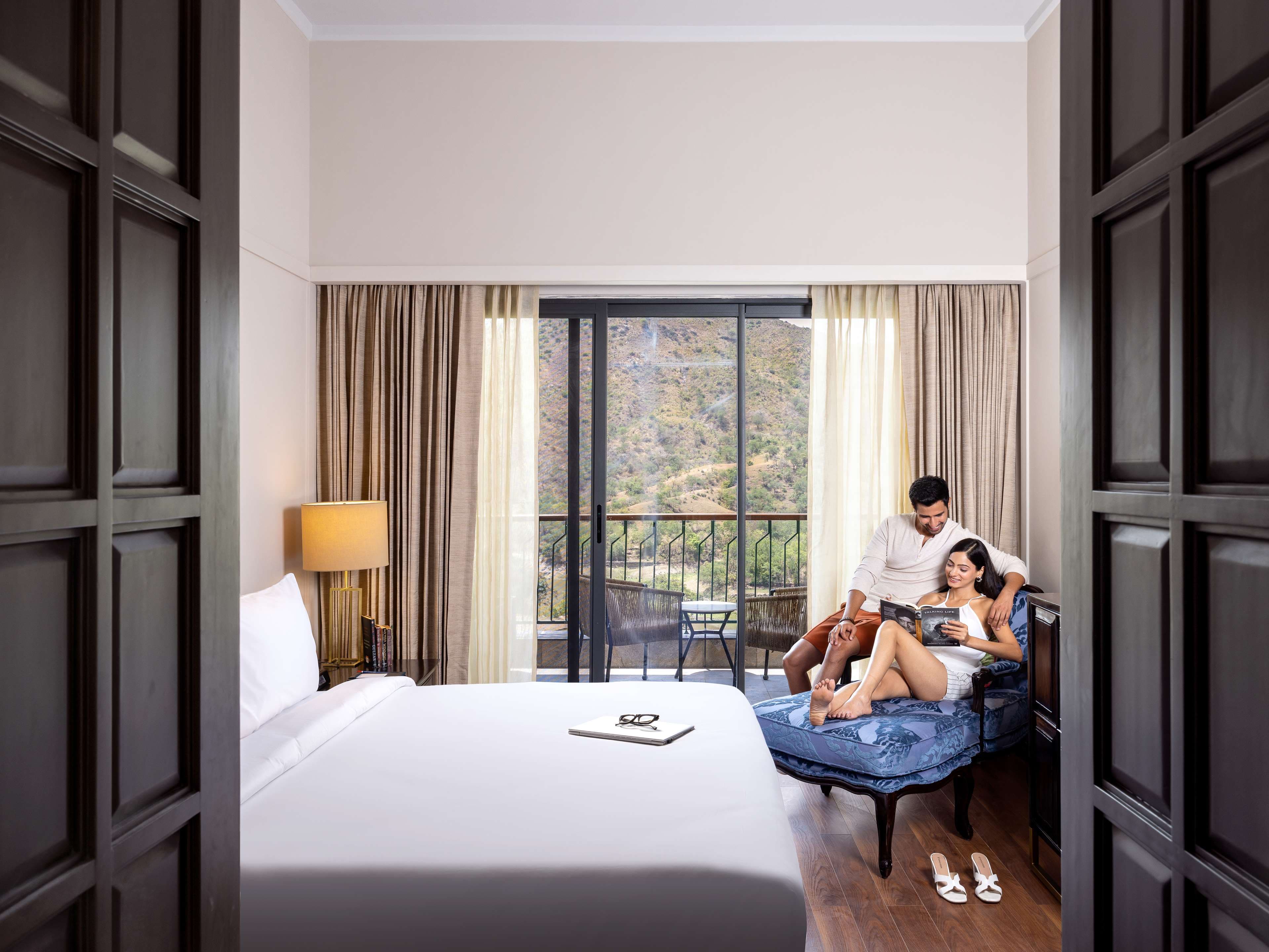 A suite bedroom at Radisson Blu Resort Kumbhalgarh with wide glazing onto the Aravalli hills