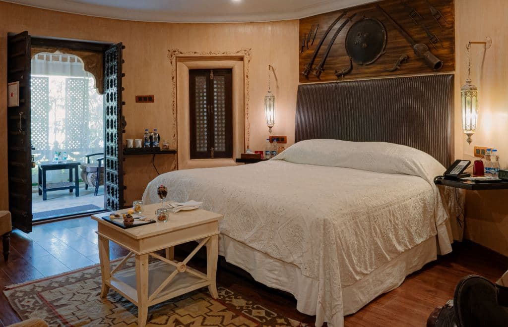 A Vintage Suite bedroom at Ajit Bhawan, Jodhpur, with a carved bed and period wardrobe