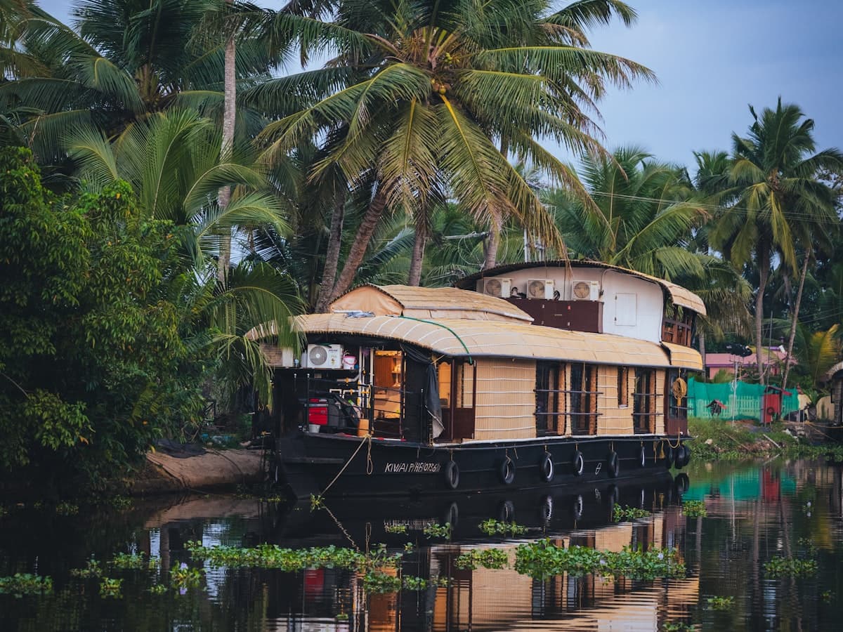 A Kerala houseboat moored against a palm-lined bank on Lake Vembanad