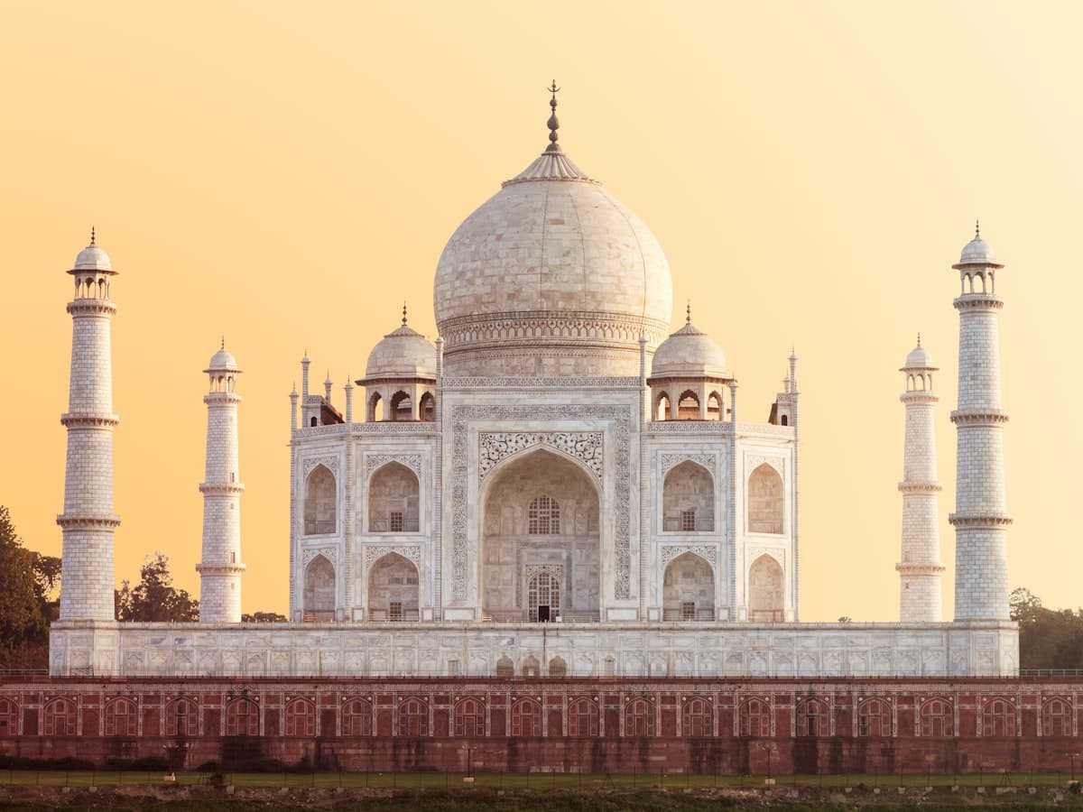 The Taj Mahal in Agra under a warm golden-hour sky