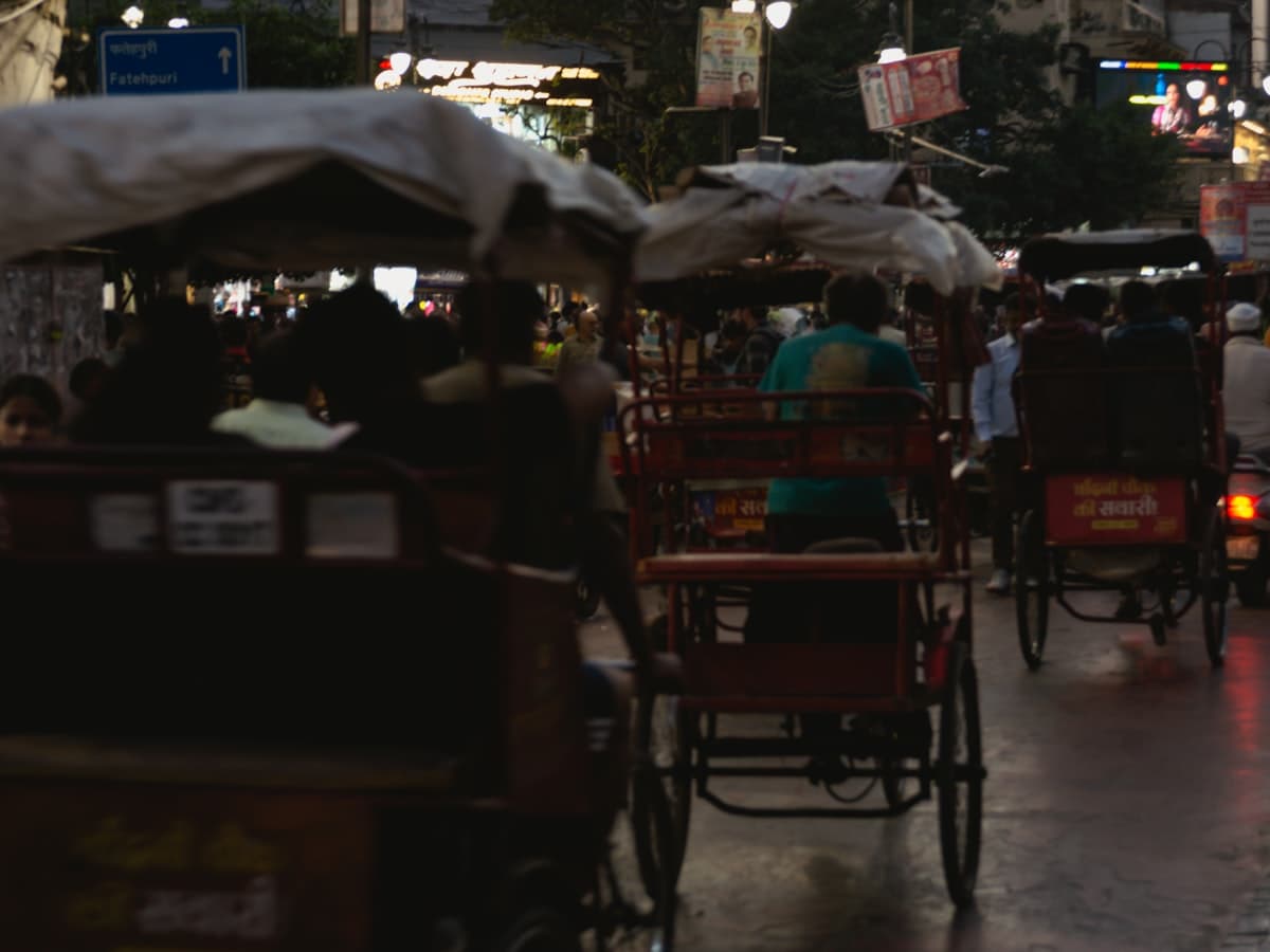 Cycle-rickshaws on a busy Old Delhi street at dusk