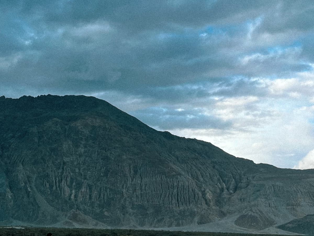 Riders on double-humped Bactrian camels crossing the Hunder dunes of Nubra Valley, a descendant tradition of the old Silk Route caravans.