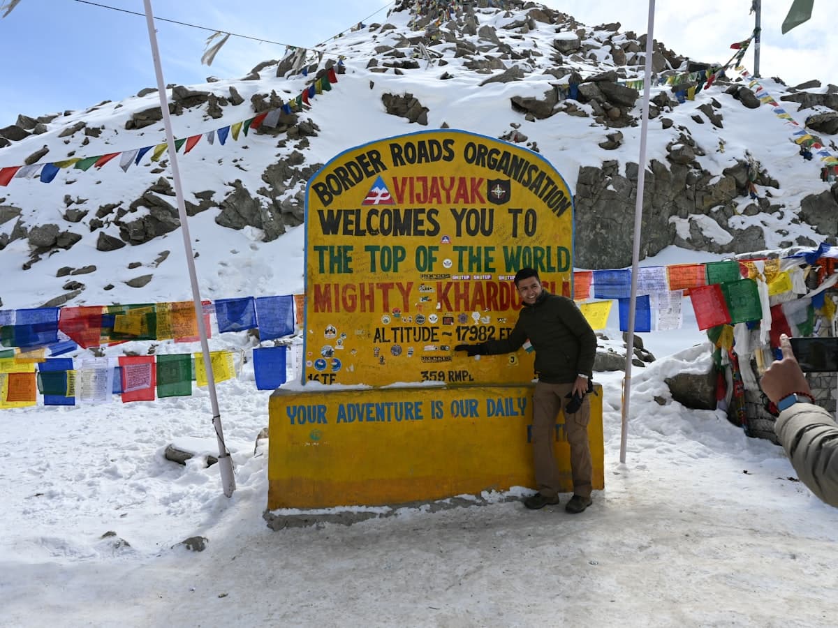 Travellers pause on a snow-covered slope at Khardung La, one of the world's highest motorable passes, on the road from Leh to the Nubra valley.