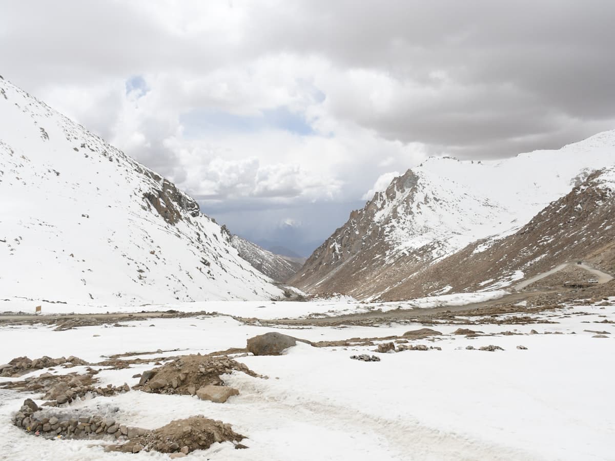 A high, snow-streaked ridge line of the Ladakh range on the return climb from Pangong toward Leh over Chang La.