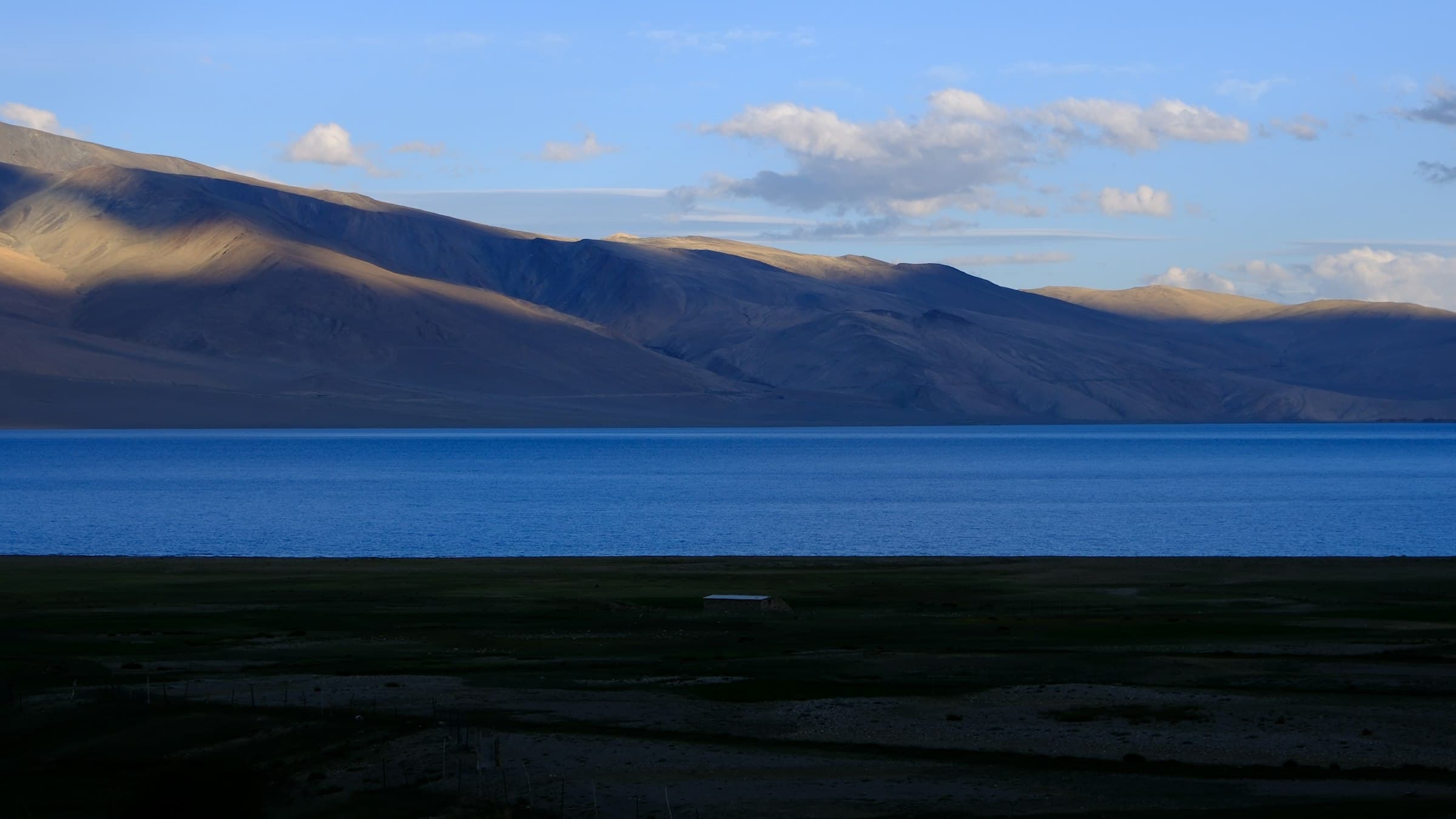 The deep blue expanse of Tso Moriri seen from the village of Korzok, ringed by the bare brown mountains of the Changthang plateau at 4,522 metres.