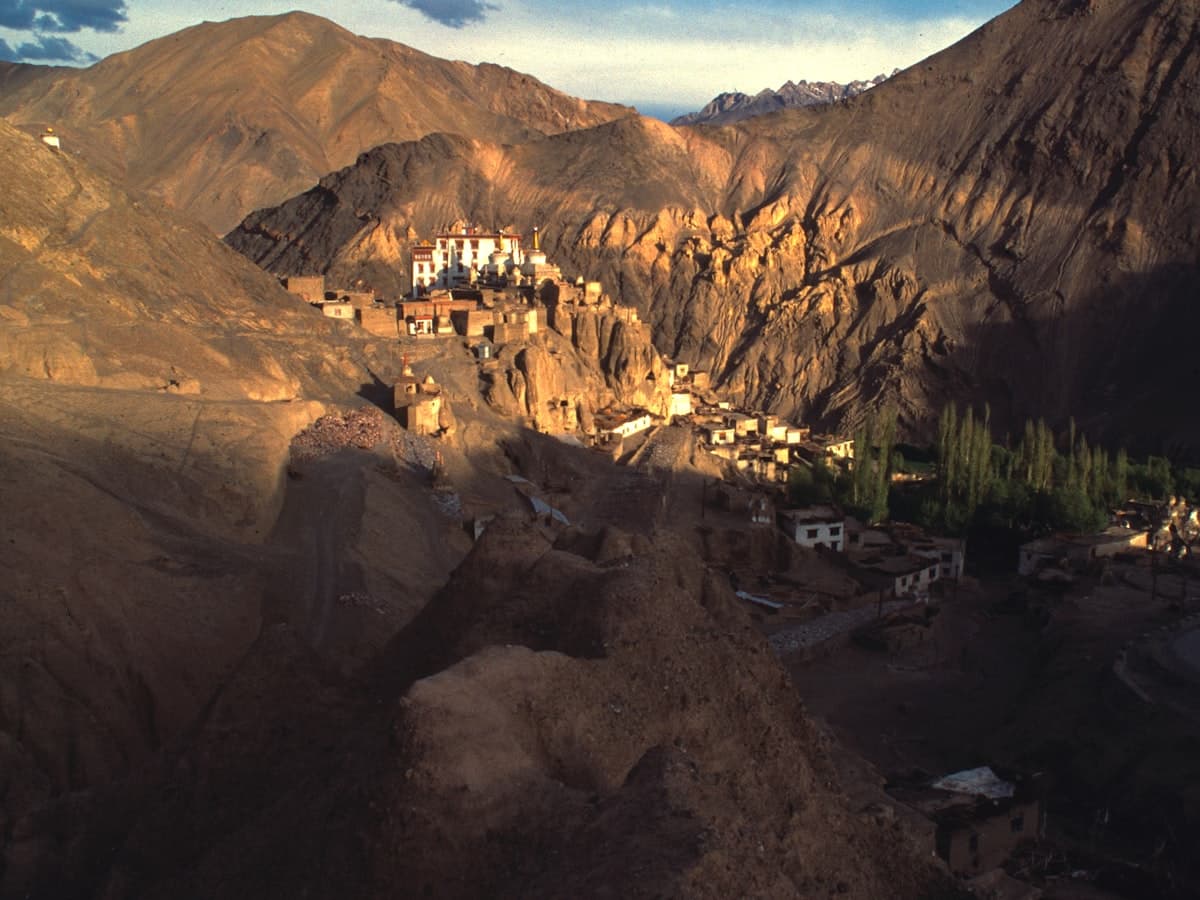 The whitewashed bulk of Lamayuru Gompa stacked on its ridge above the eroded, crumbling badlands that give the site its 'moonland' name.