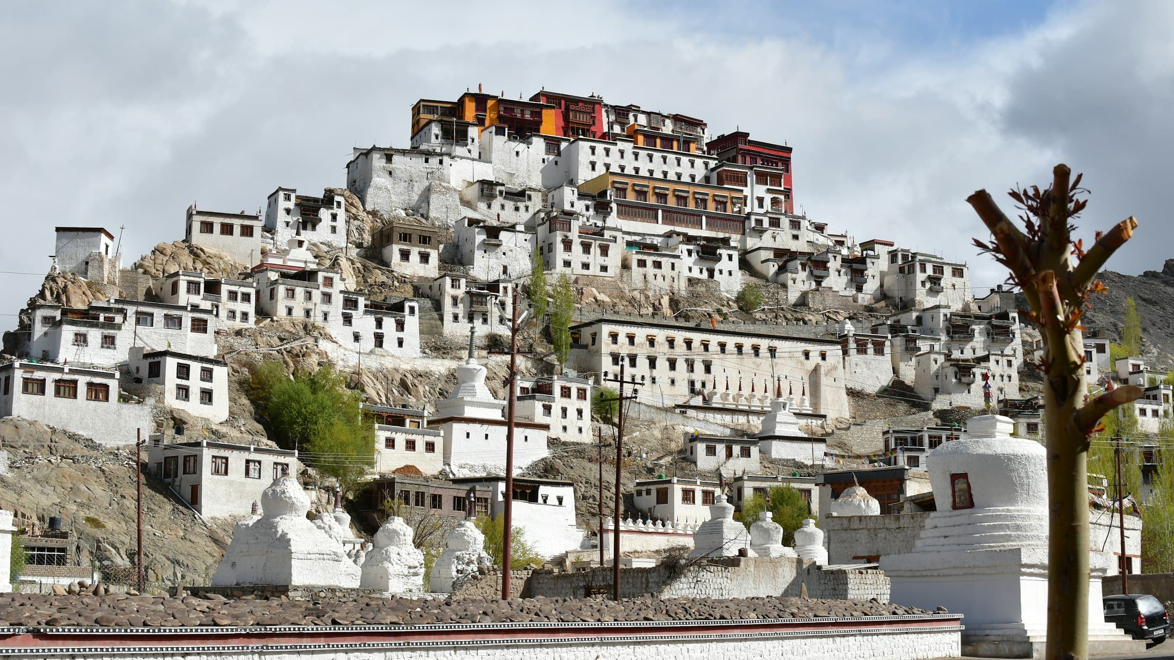 The tiered white-and-ochre buildings of Thiksey monastery cascade down their hilltop above the Indus plain.