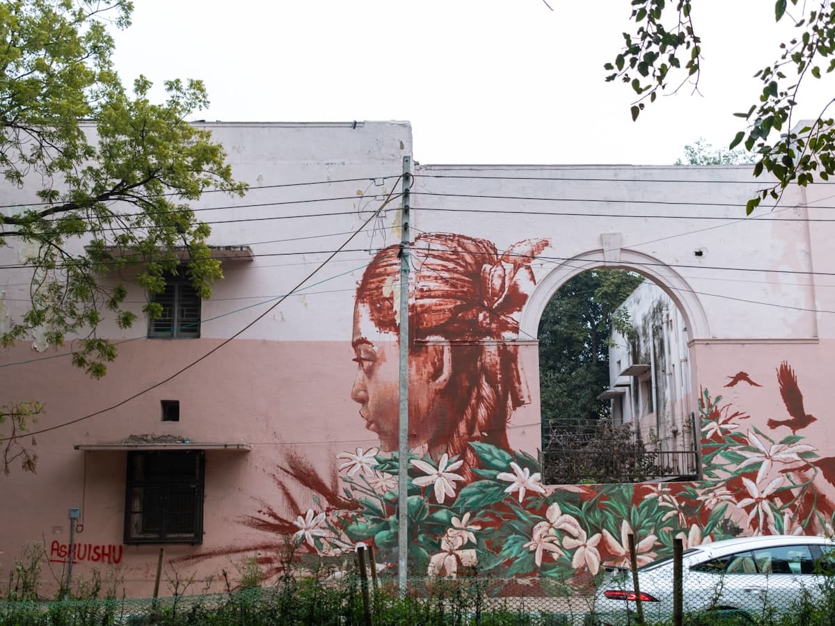 A large painted mural covering the side of a residential block in the Lodhi Art District of Lodi Colony, New Delhi.