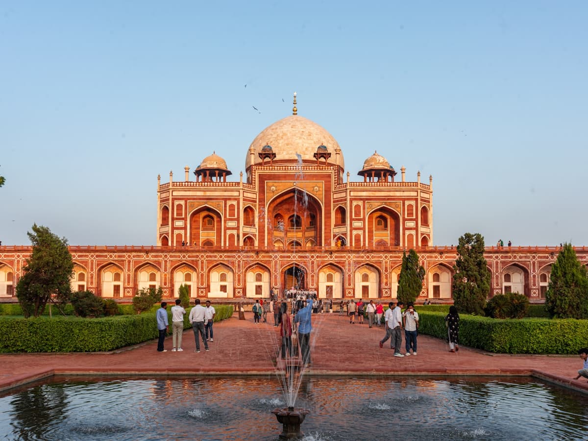 Humayun's Tomb in Delhi, its red sandstone dome and arched iwan mirrored in the char-bagh reflecting channel.