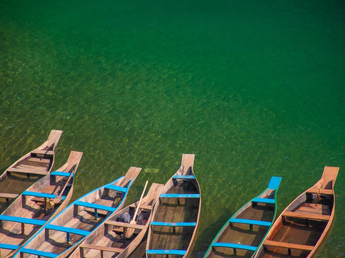 A wooden boat resting on the transparent green water of the Umngot River at Dawki, Meghalaya.