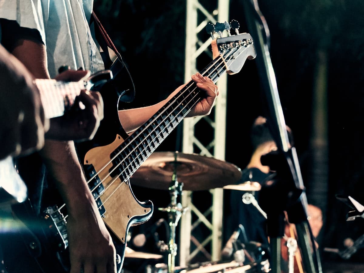 A musician playing electric guitar on a dim stage during a live performance.