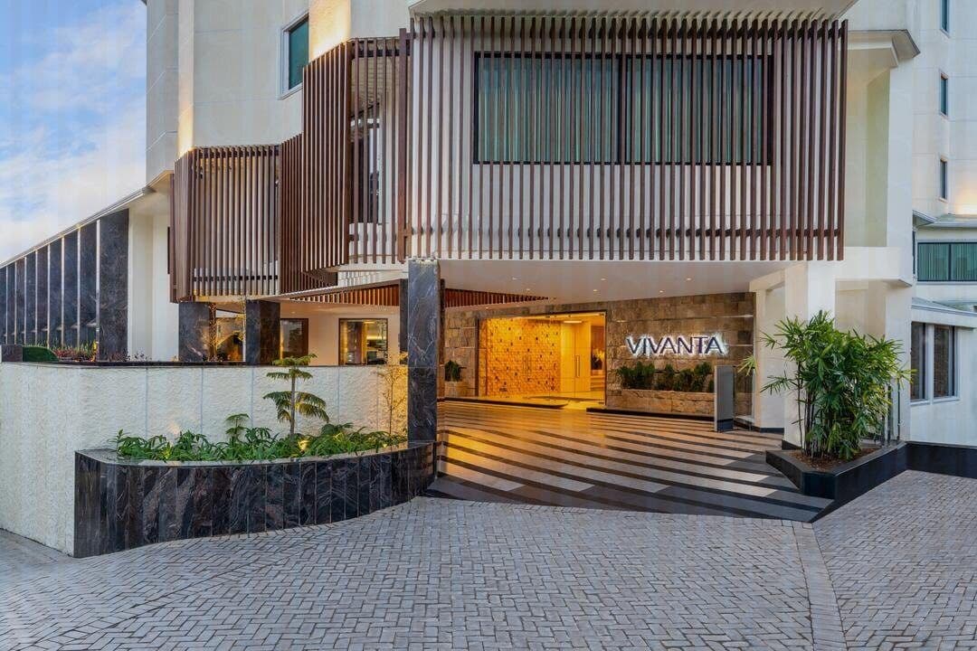 The porte-cochere entrance of Vivanta Meghalaya, Shillong with the lit Vivanta signage over the doors.