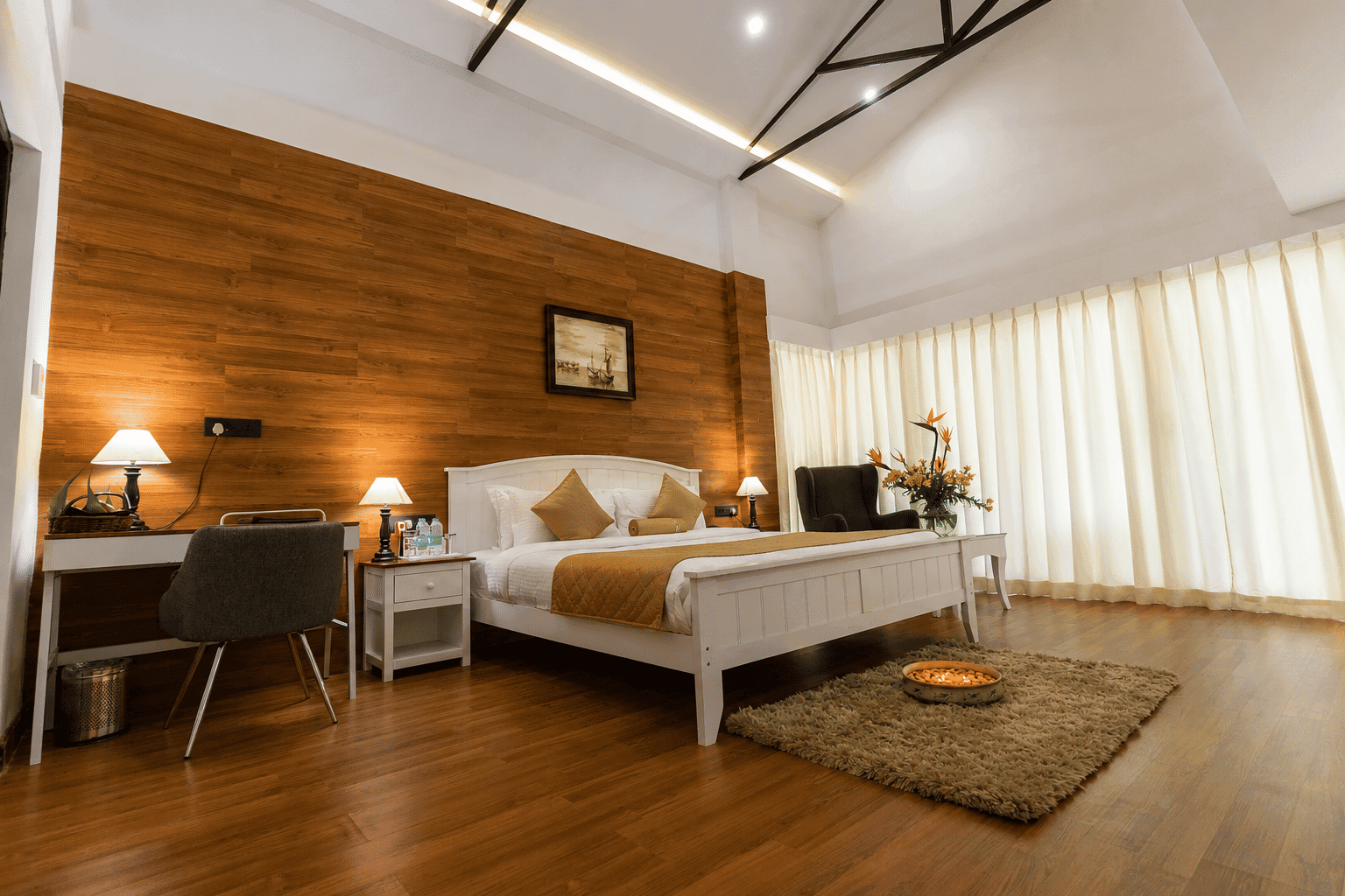 A valley-view guest room at Polo Orchid Resort, Cherrapunji with a wooden bed, mustard runner and desk.