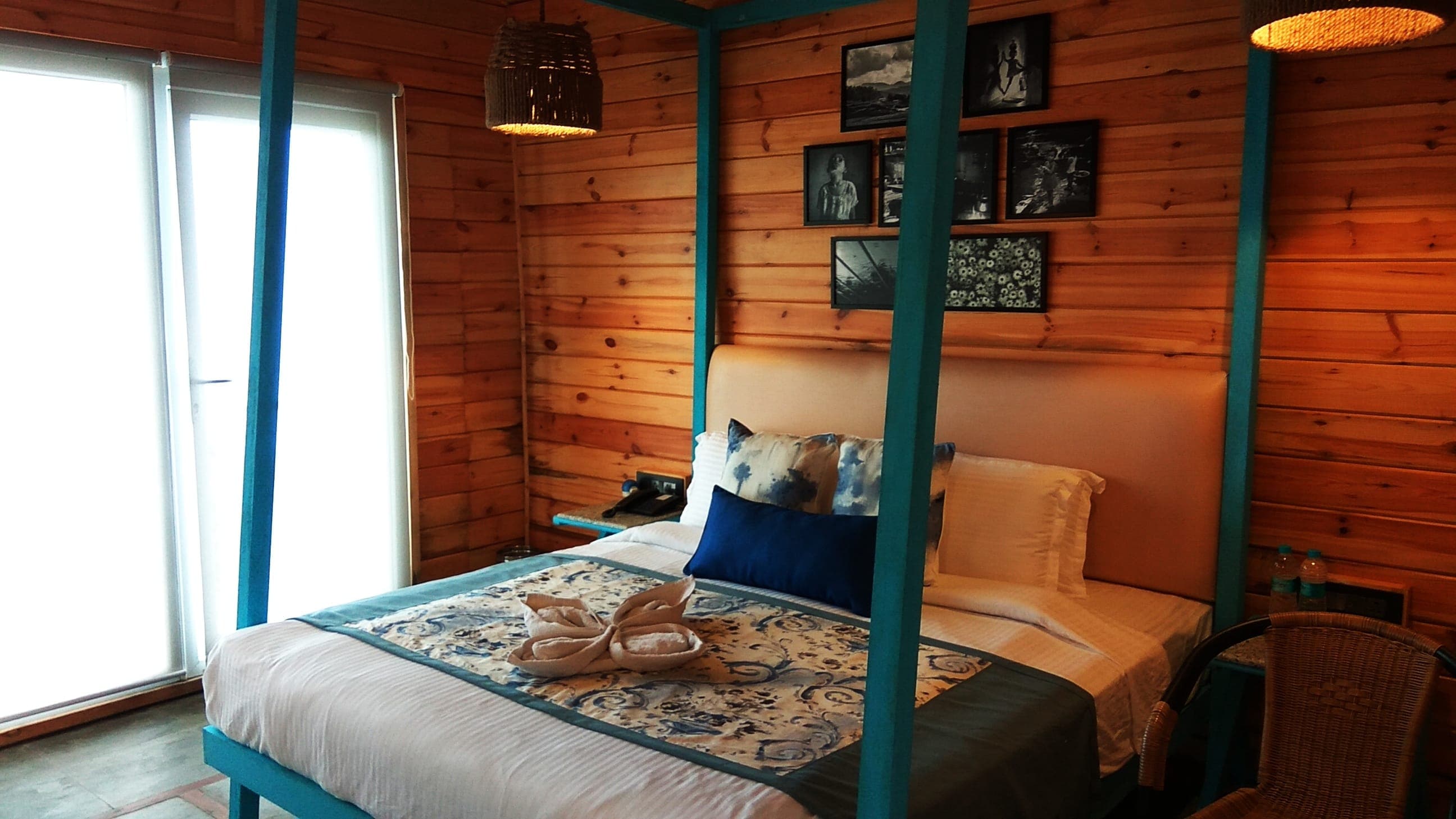 The teal four-poster bed inside a Log Hut cottage at Polo Orchid Resort, Cherrapunji.