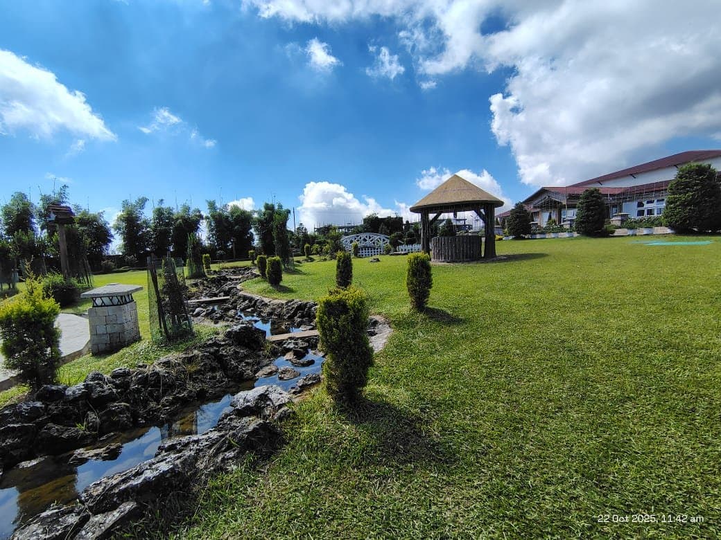 The main block of Jiva Resort, Sohra rising behind its manicured lawns, rock garden and gazebo.
