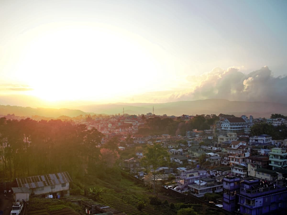 Shillong town spread across pine-clad hills at dusk, seen from the Don Bosco Museum viewpoint.